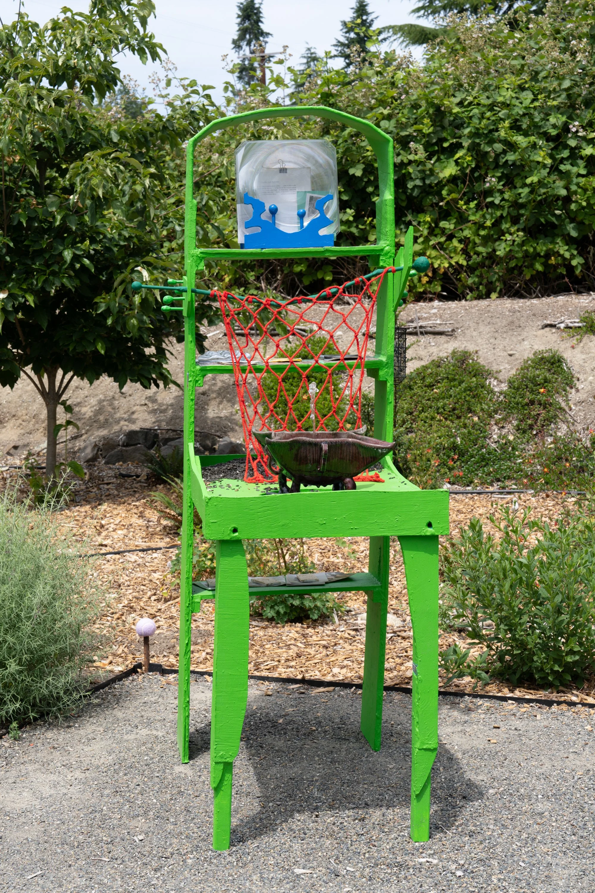 A green sculpture in a garden.