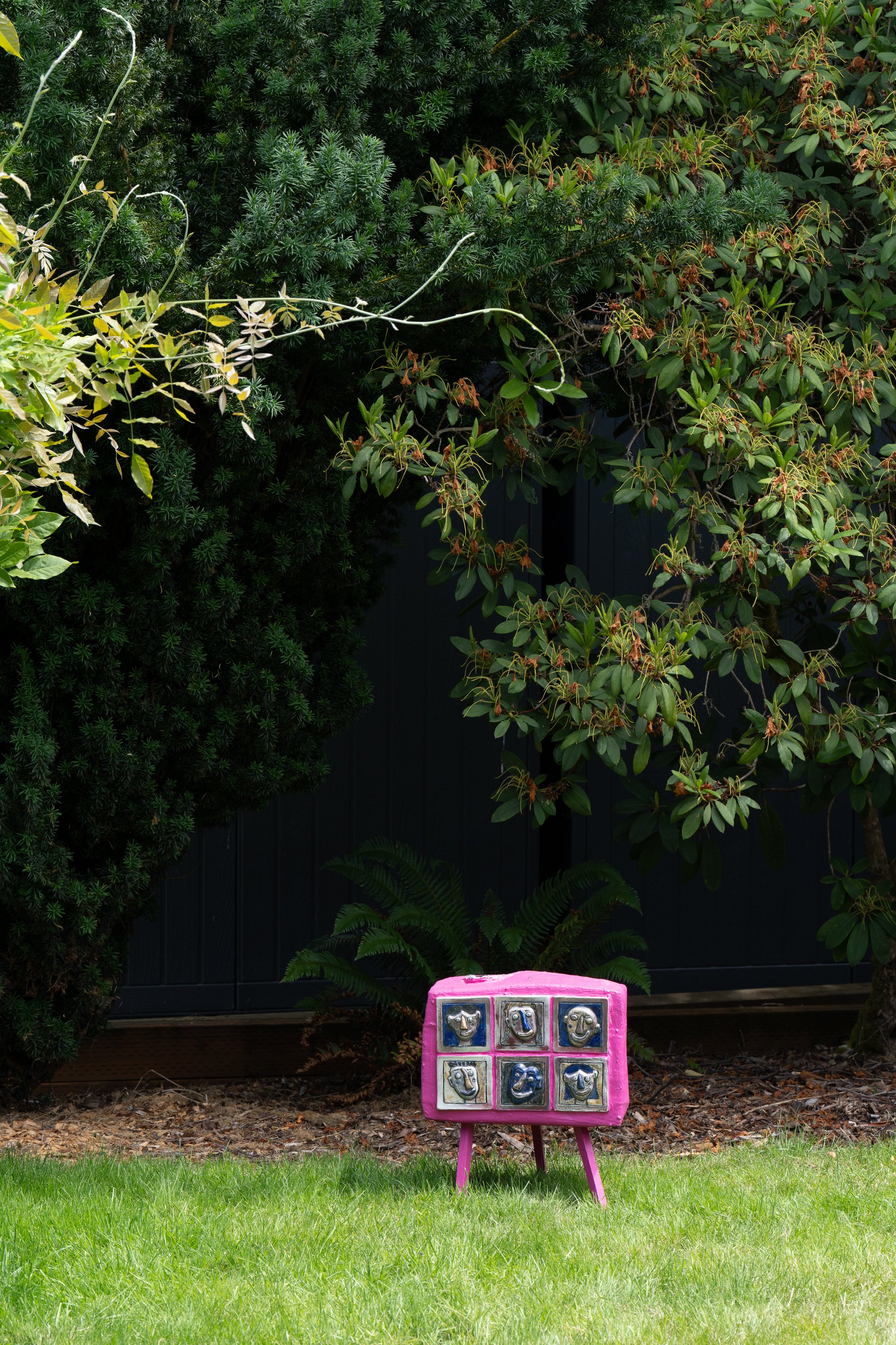 A pink sculpture on a lawn.