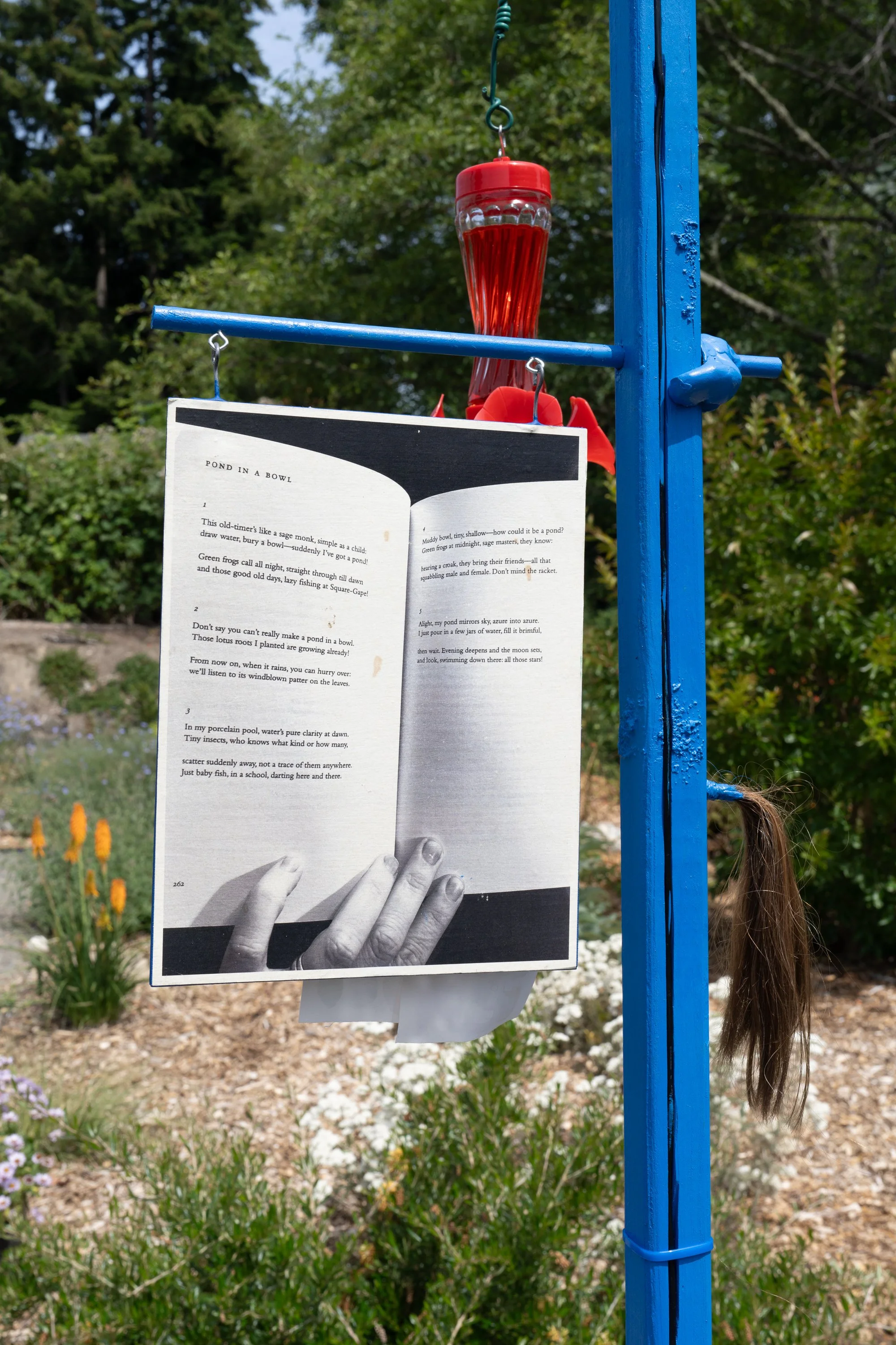 A photo of an open book hung on a blue sculpture.