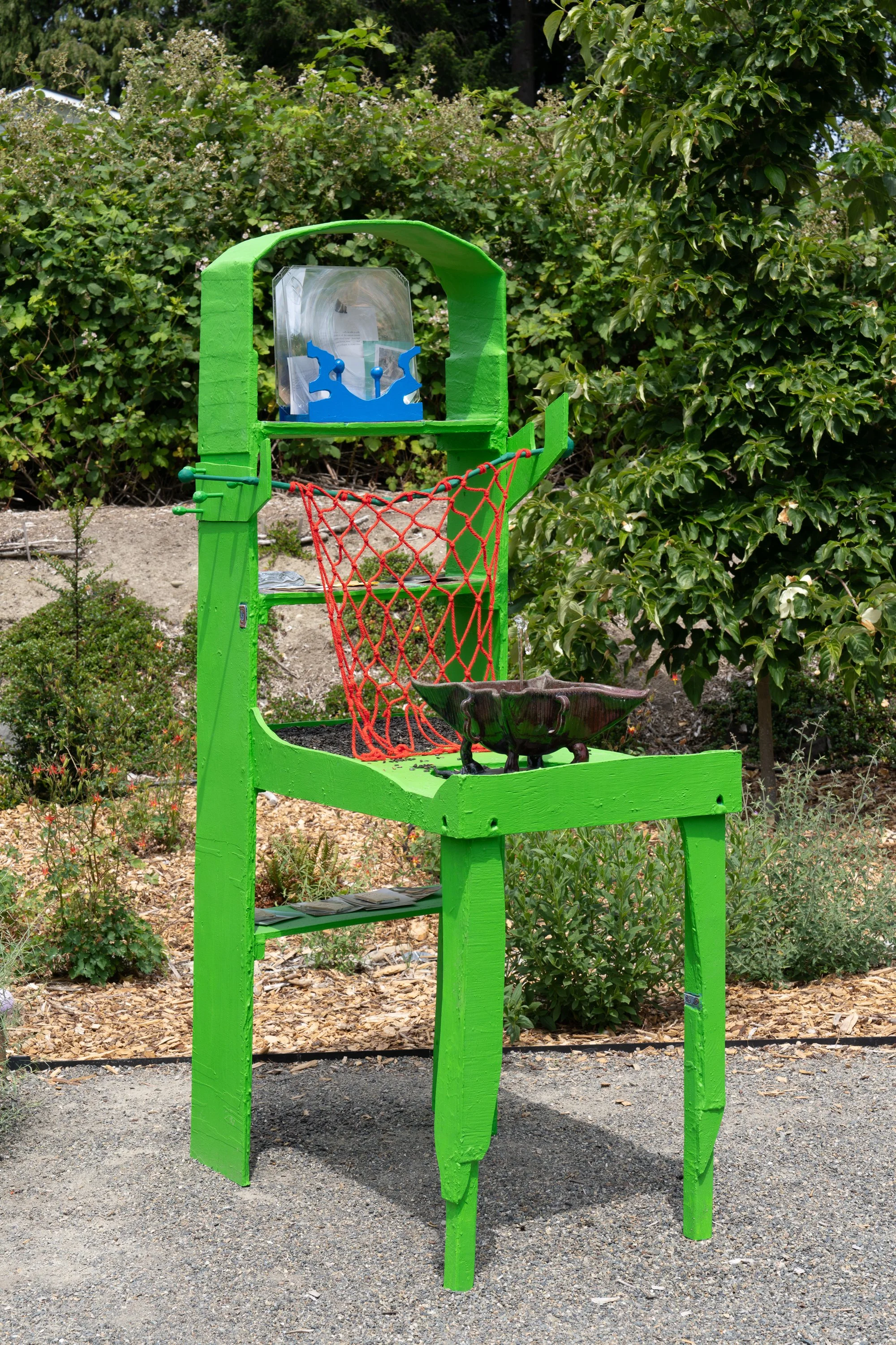 A green sculpture in a garden.