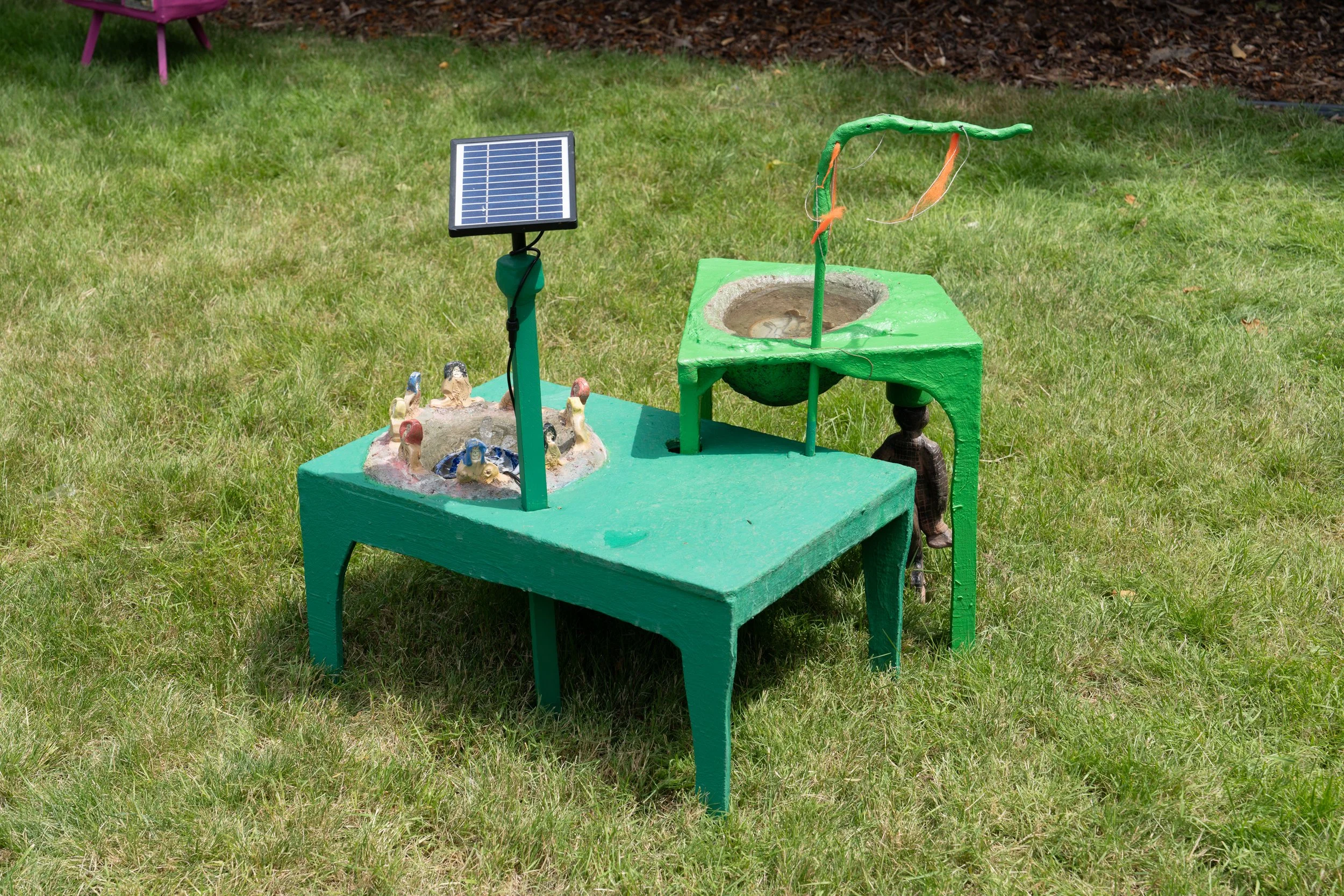 A green sculpture on a lawn.