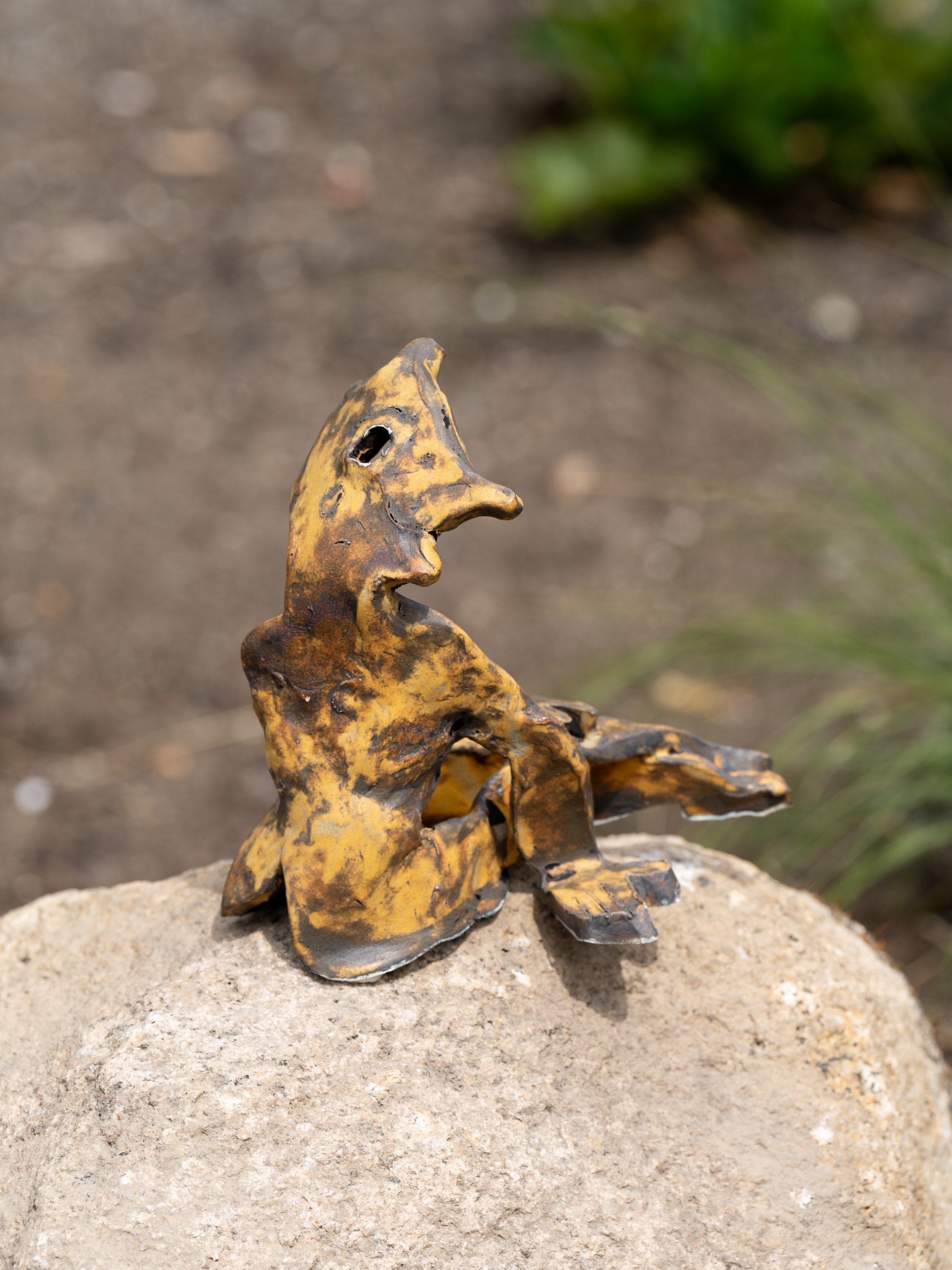 A ceramic figure on a rock.