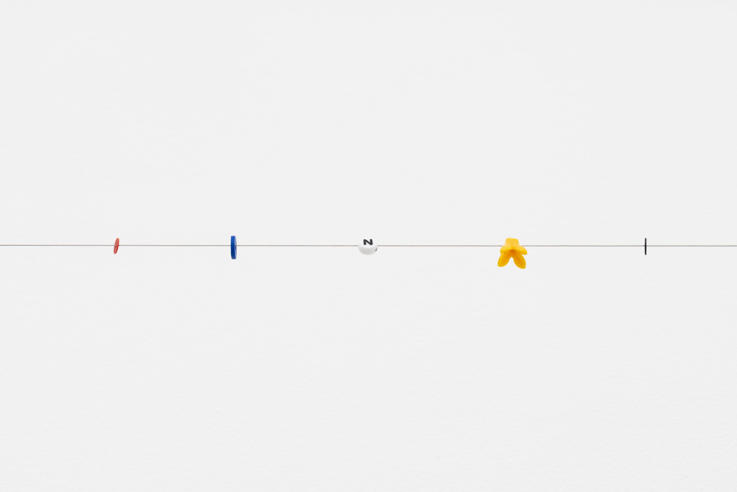 small beads on a wire; one of them reads letter N