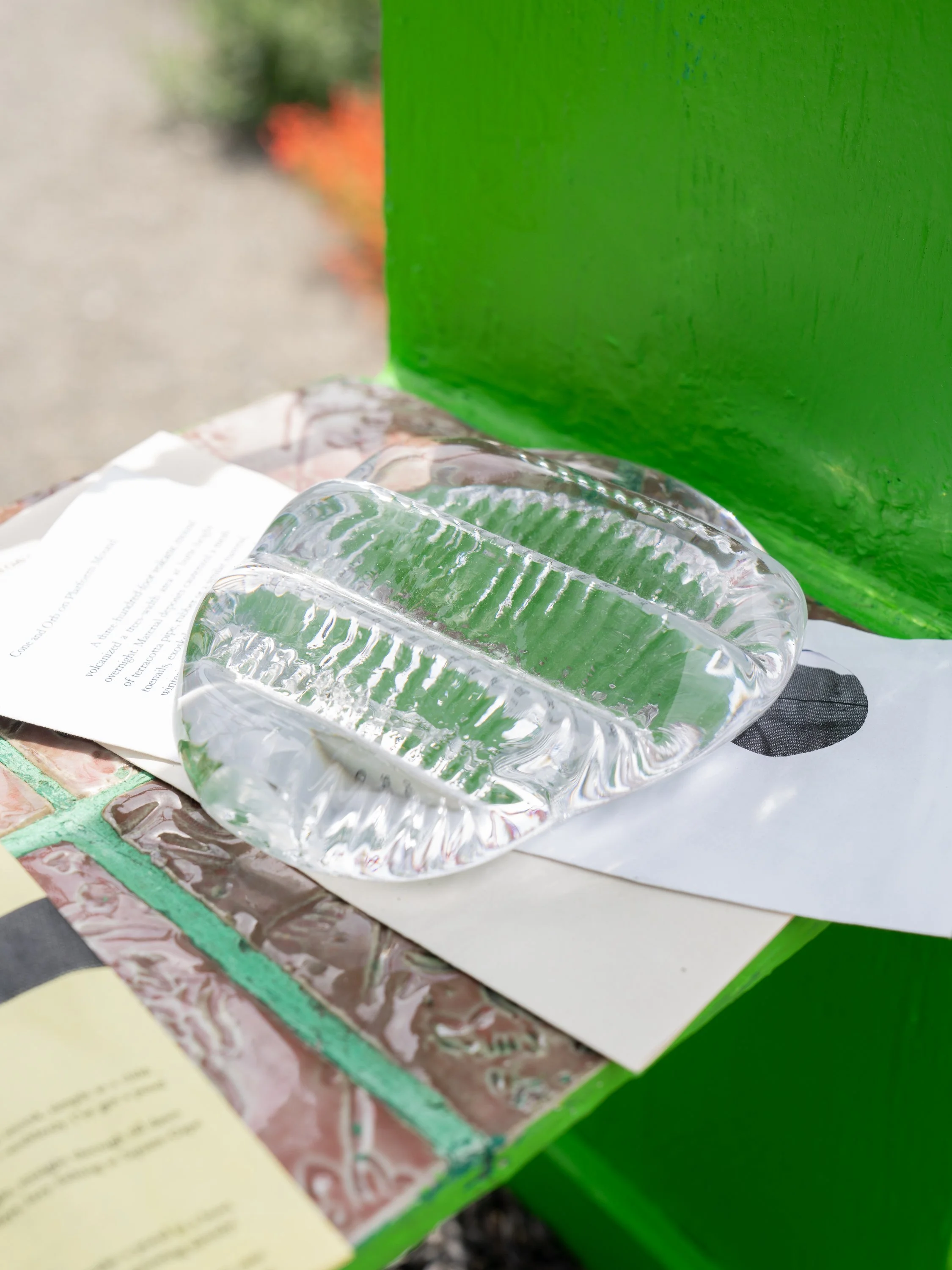 A glass sculpture on folded paper.
