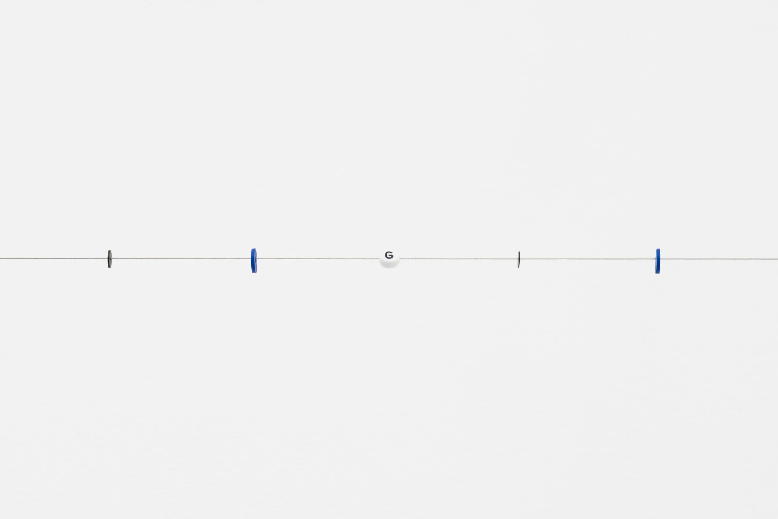 small beads on a wire; one of them reads letter G