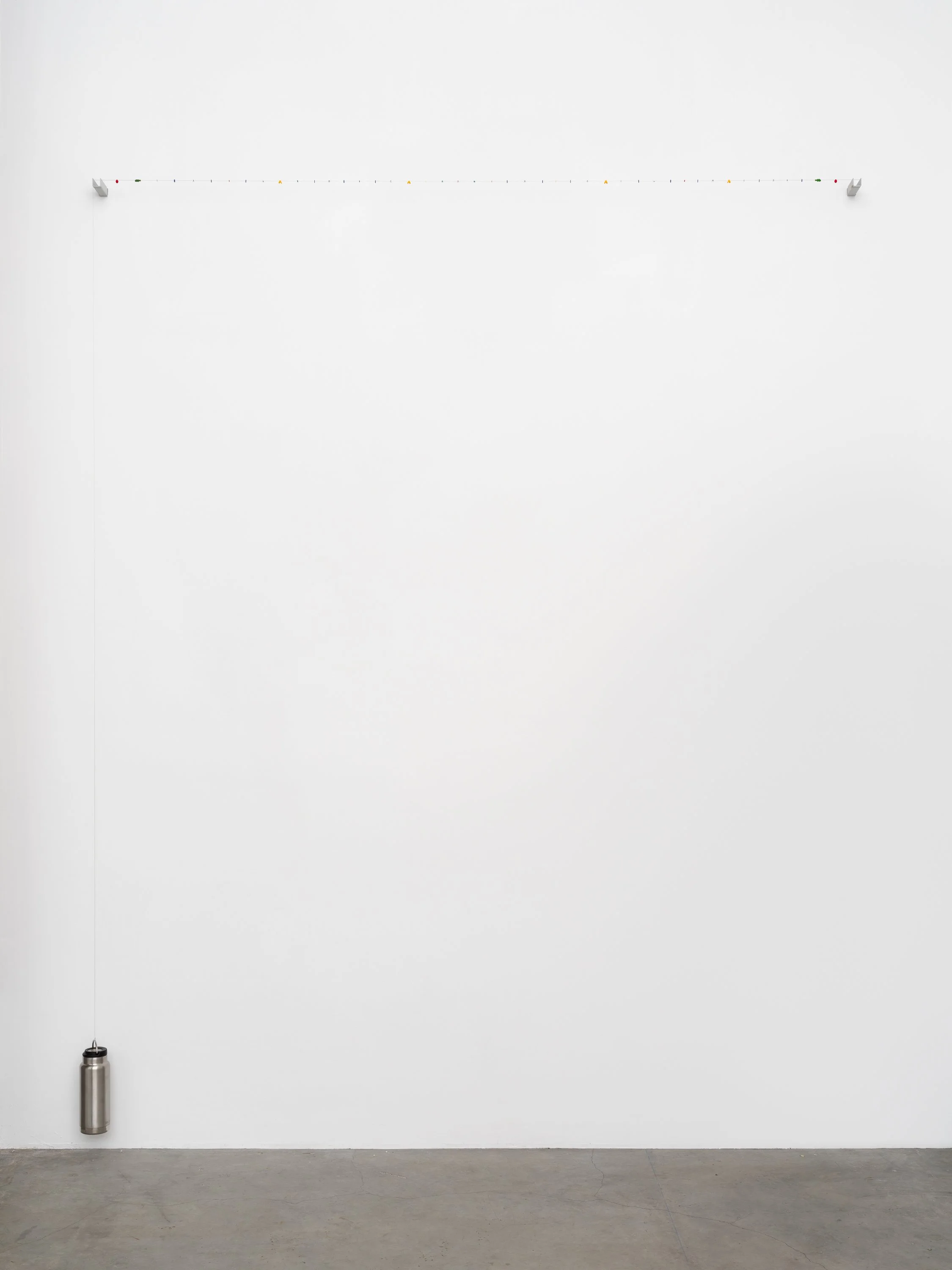 A string of small objects held tight by a water bottle.