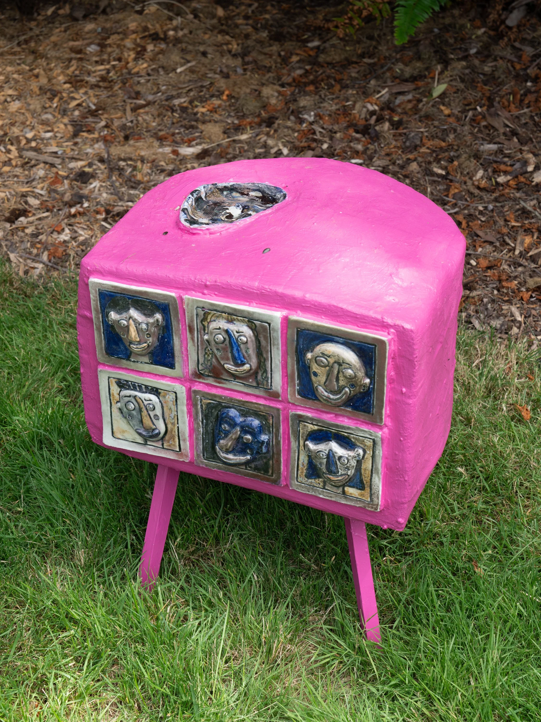 A pink sculpture on a lawn.