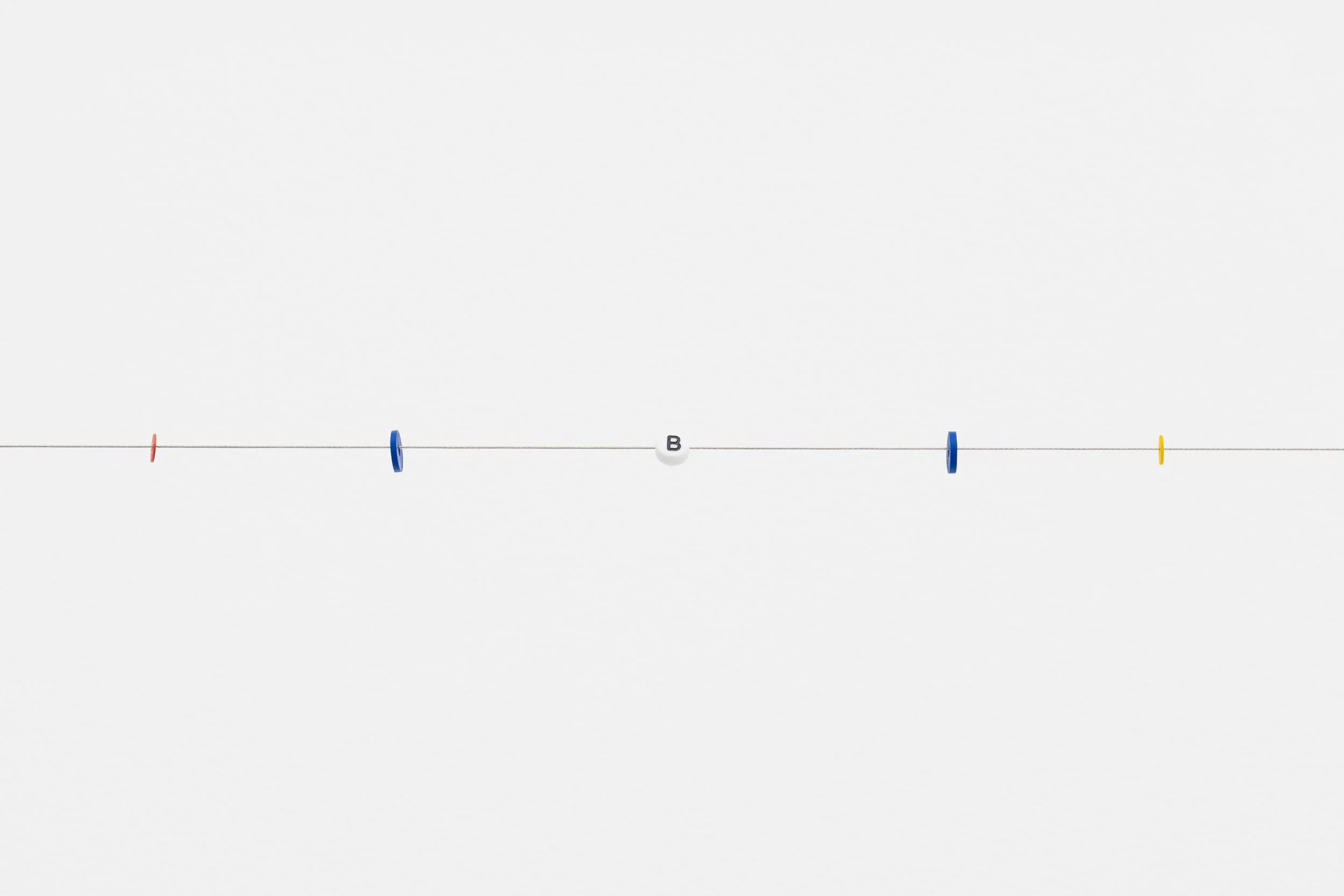 small beads on a wire; one of them reads letter B