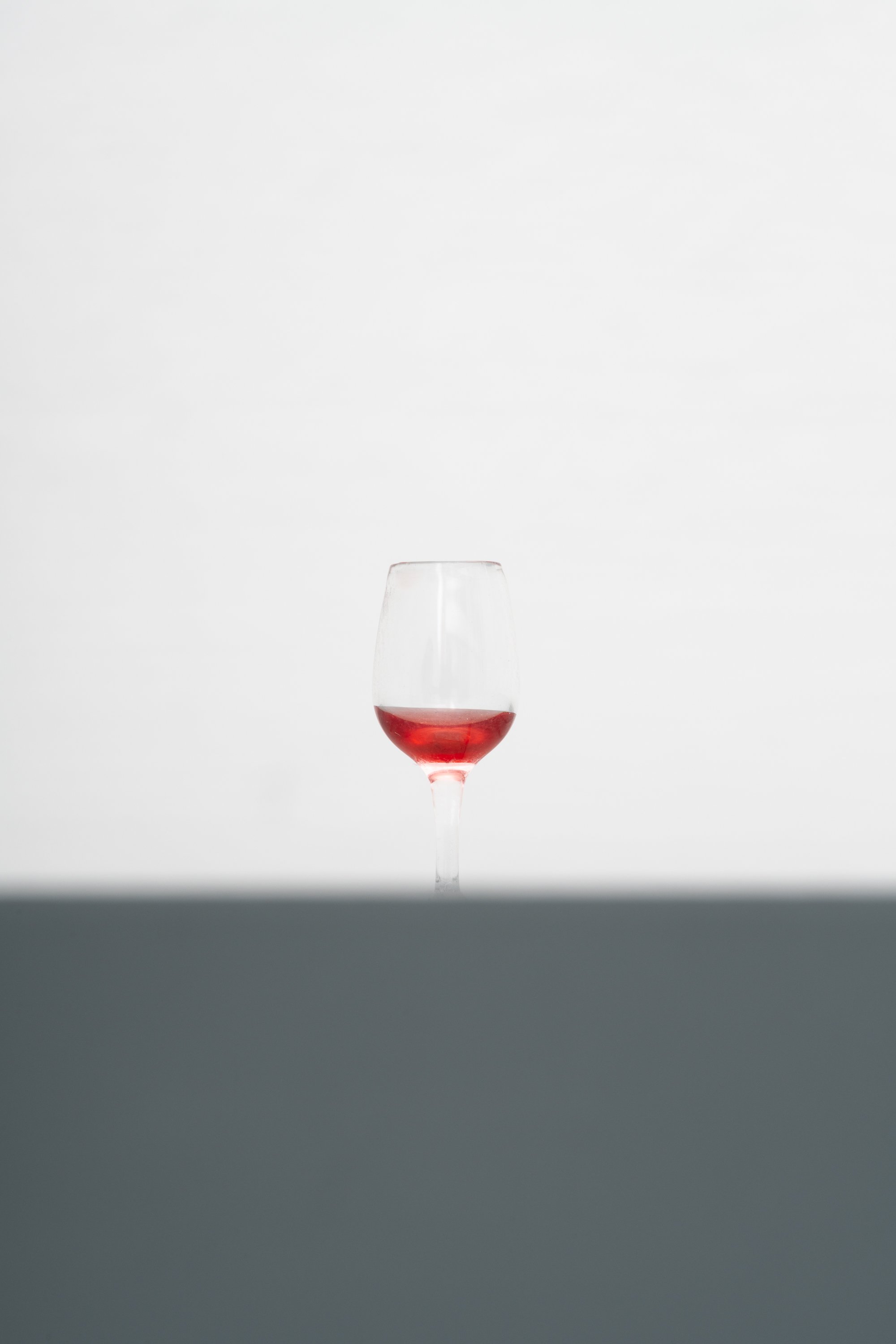 a tiny wine glass with leftover red wine