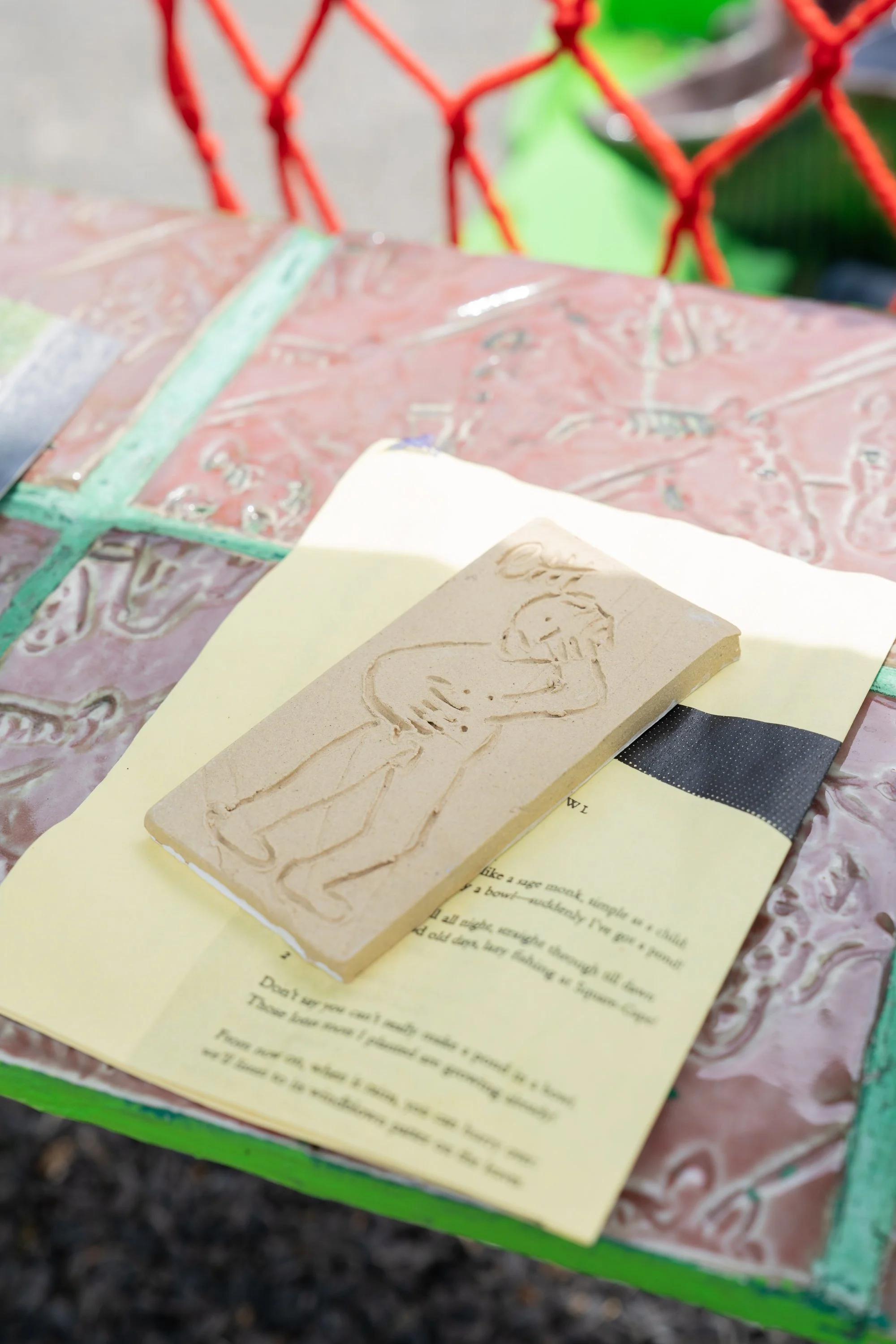 A ceramic tile on folded paper.