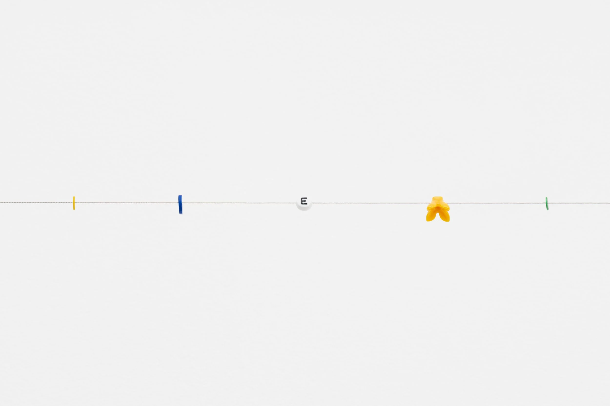 small beads on a wire; one of them reads letter E