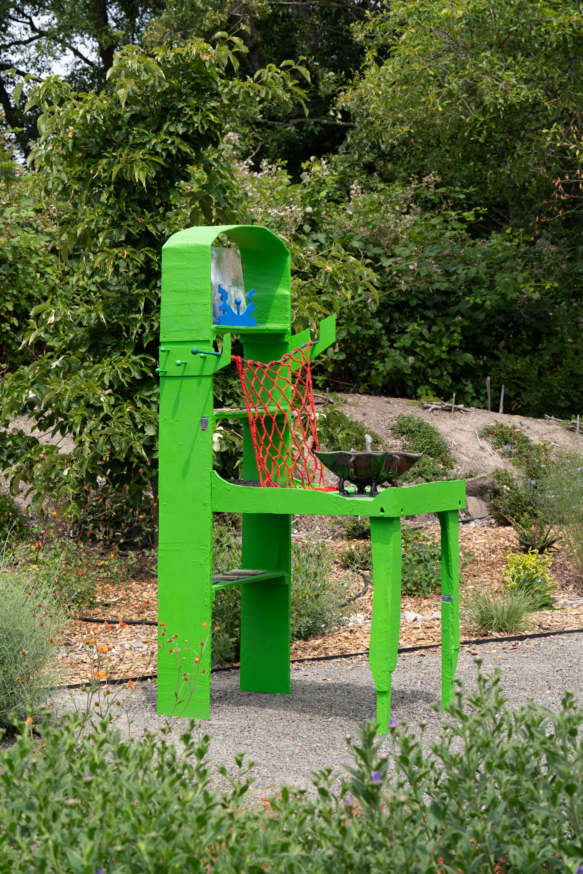A green sculpture in a garden.