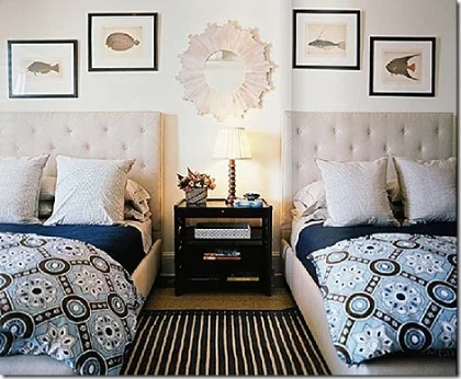 Bedroom with two beds, carpet and frames on wall