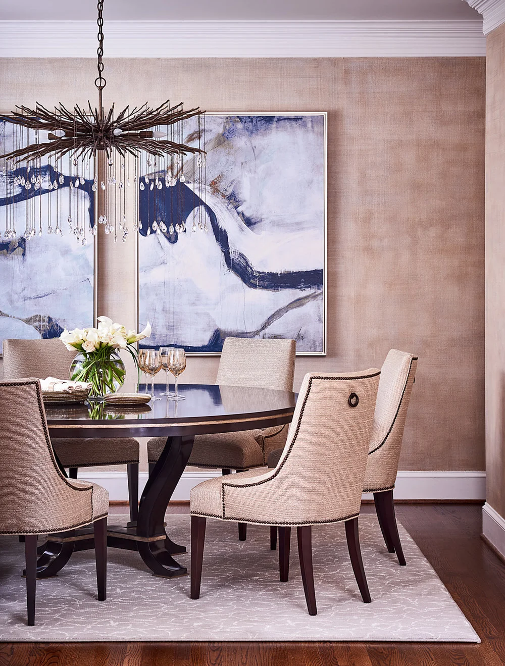 Modern dining room with round wooden table and artwork on wall