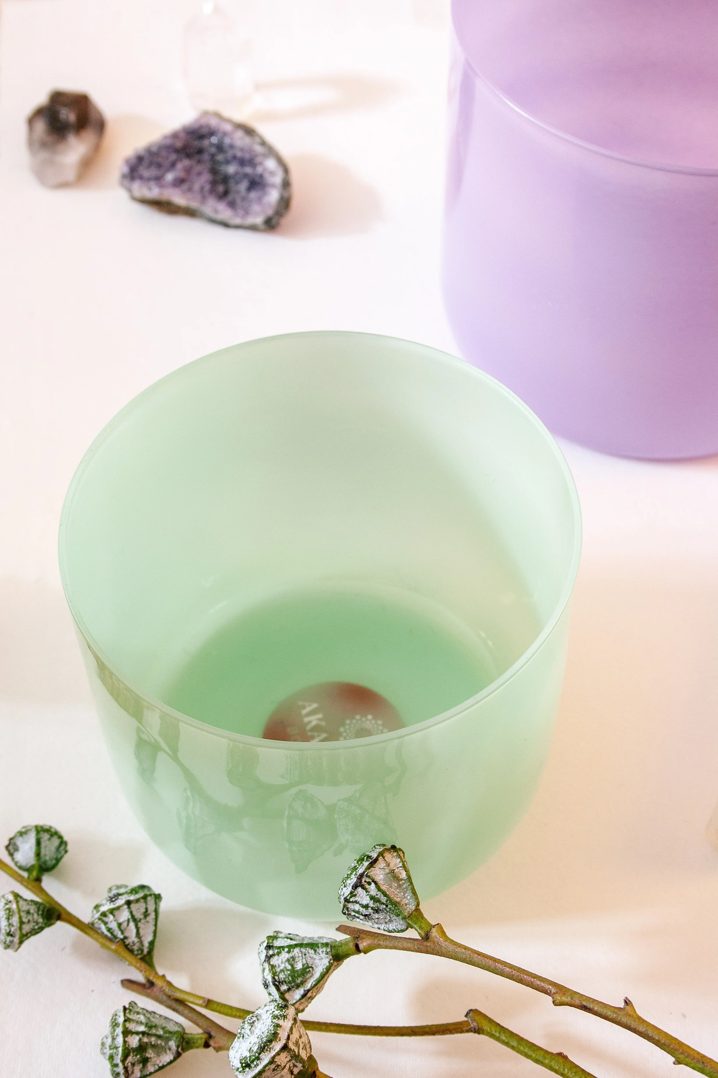 Grüne Kristall-Klangschale (AkashaBowl®) auf natürlicher Unterlage