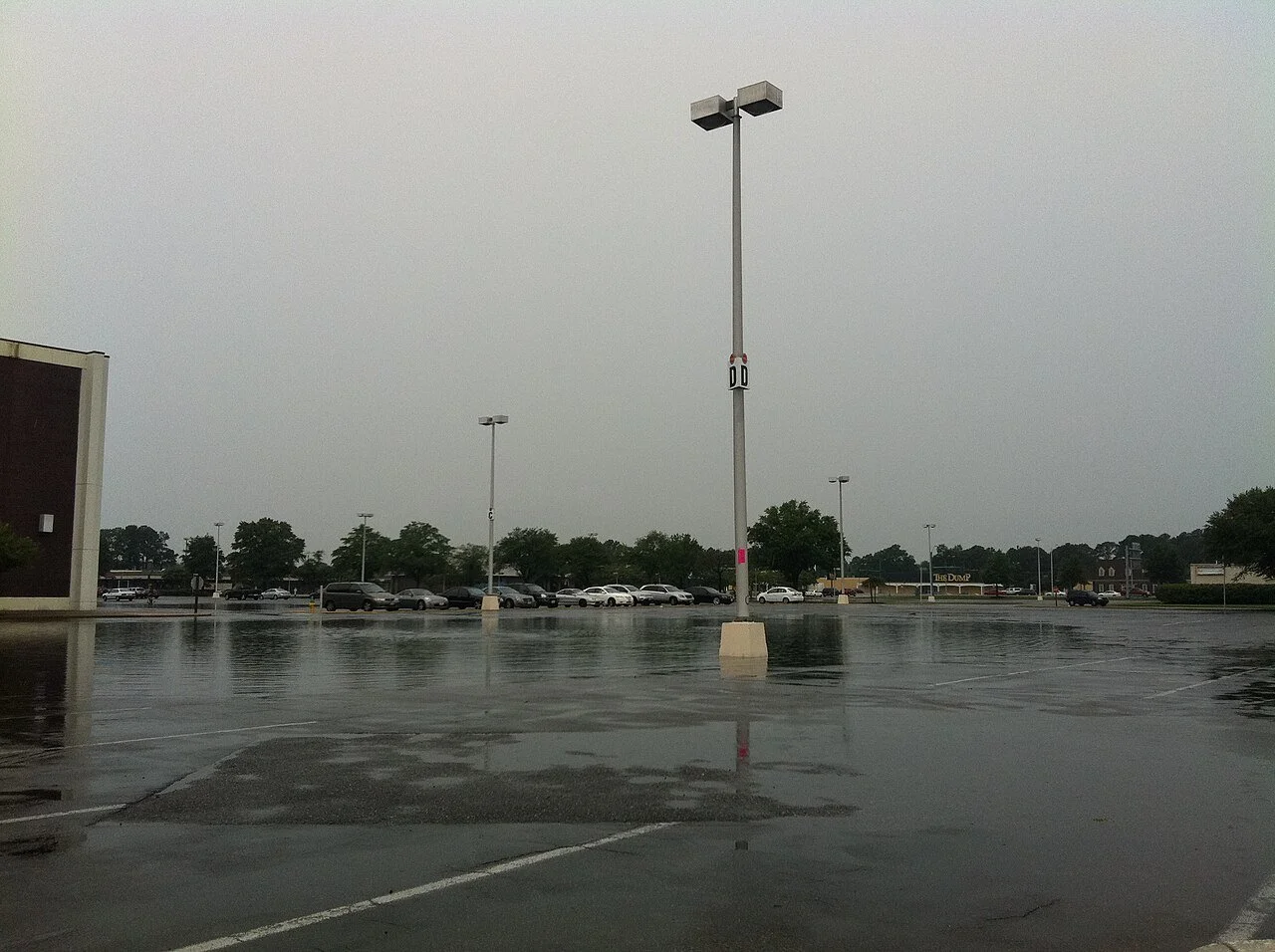 A flooded parking lot on a cloudy day.