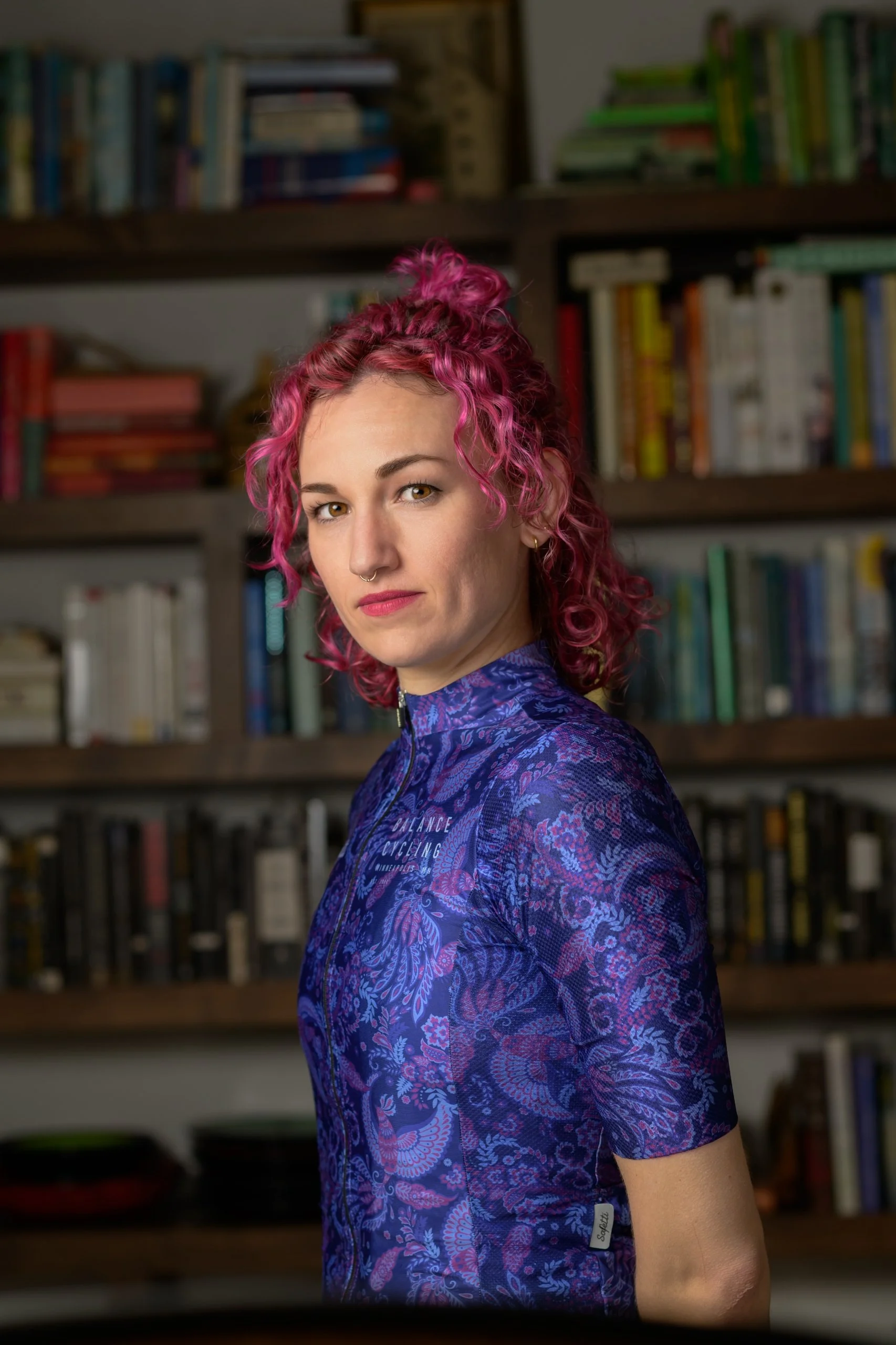 Person identified as Kiki Hoogenakker has shoulder length hair and is wearing a bike jersey.