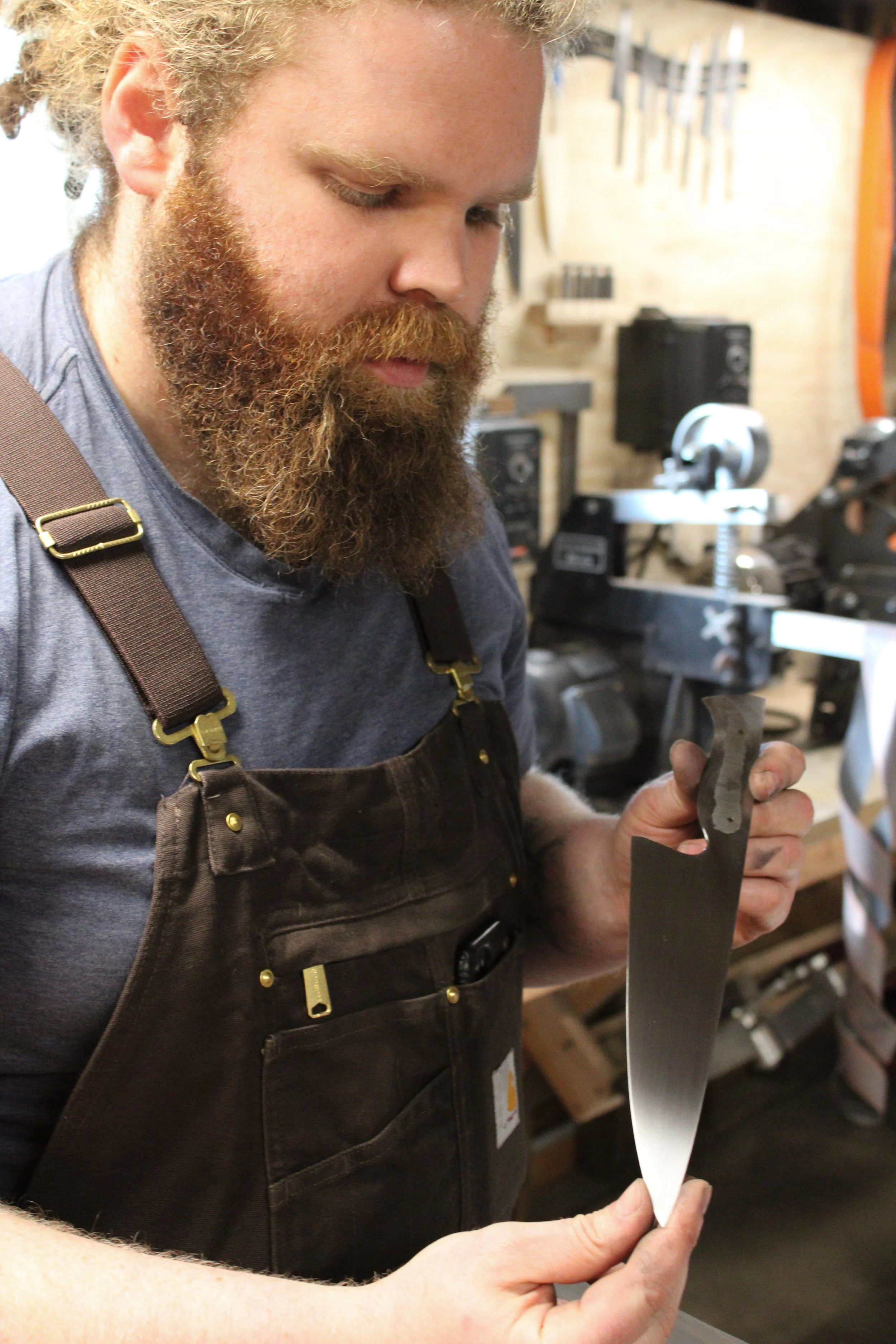 Image of me looking for scratches in a blade while hand sanding.