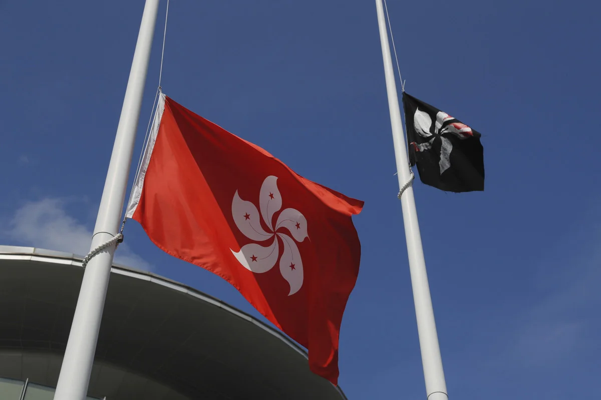 香港民眾將中國國旗撤下,改升起黑色紫荊旗,並將香港特區旗降半旗。攝:Kin Cheung/Associated Press