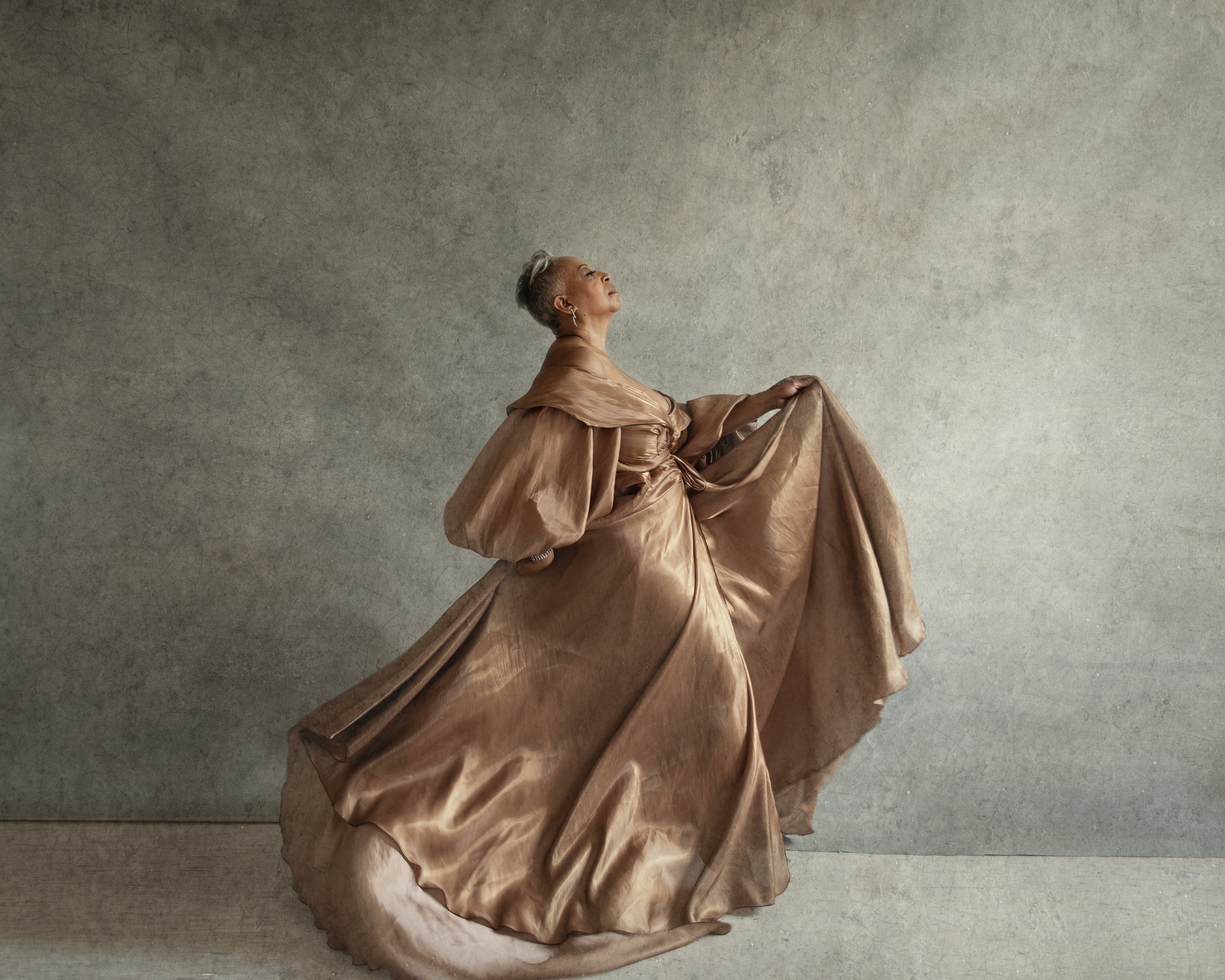 A graceful woman in a long dress dancing, showcasing beauty and movement in a stunning Miami photoshoot by Pilar Andujar.