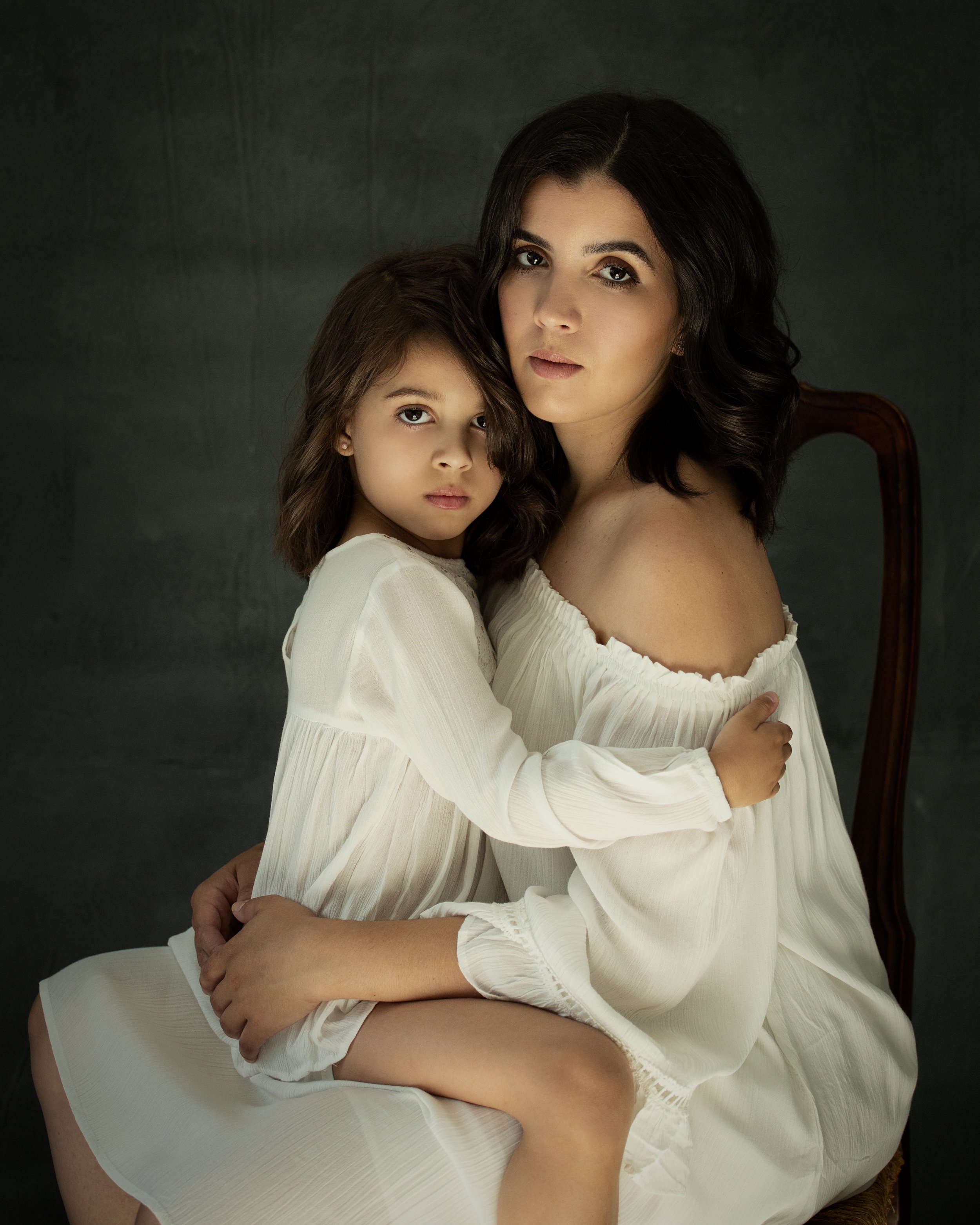 A mother and daughter sitting on a chair during a photography Miami Pilar Andujar mother daughter photoshoot.