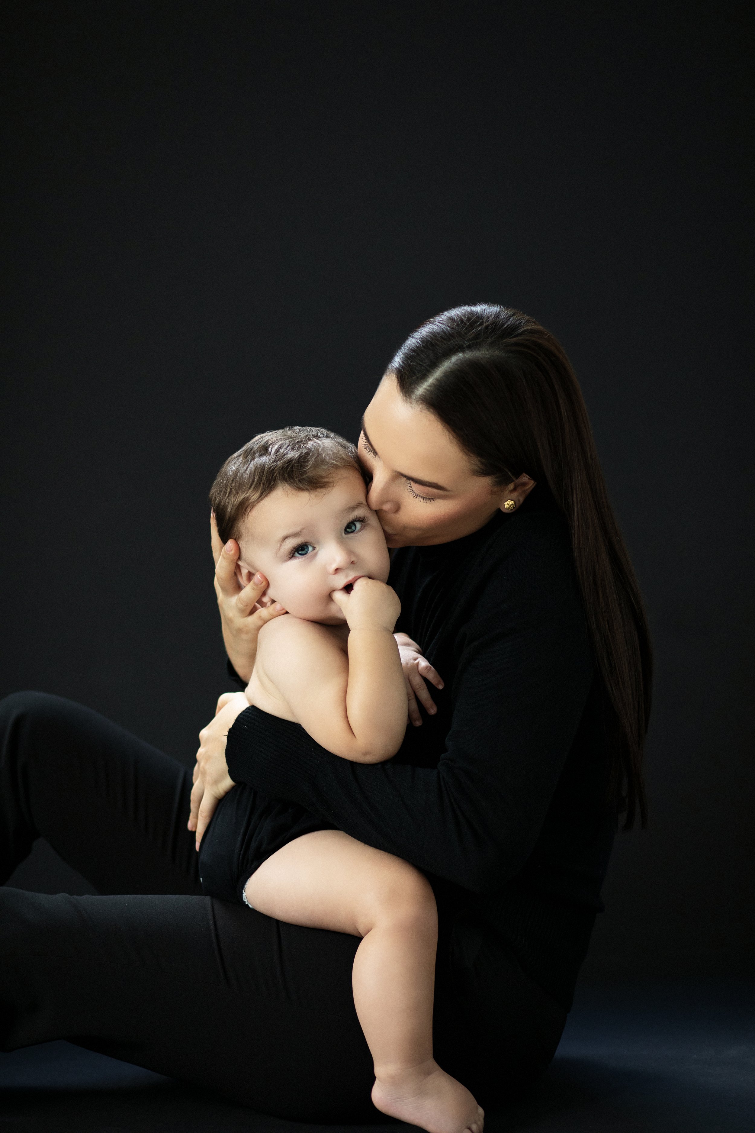 A woman lovingly holds a baby in her arms during a photoshoot in Miami by Pilar Andujar.