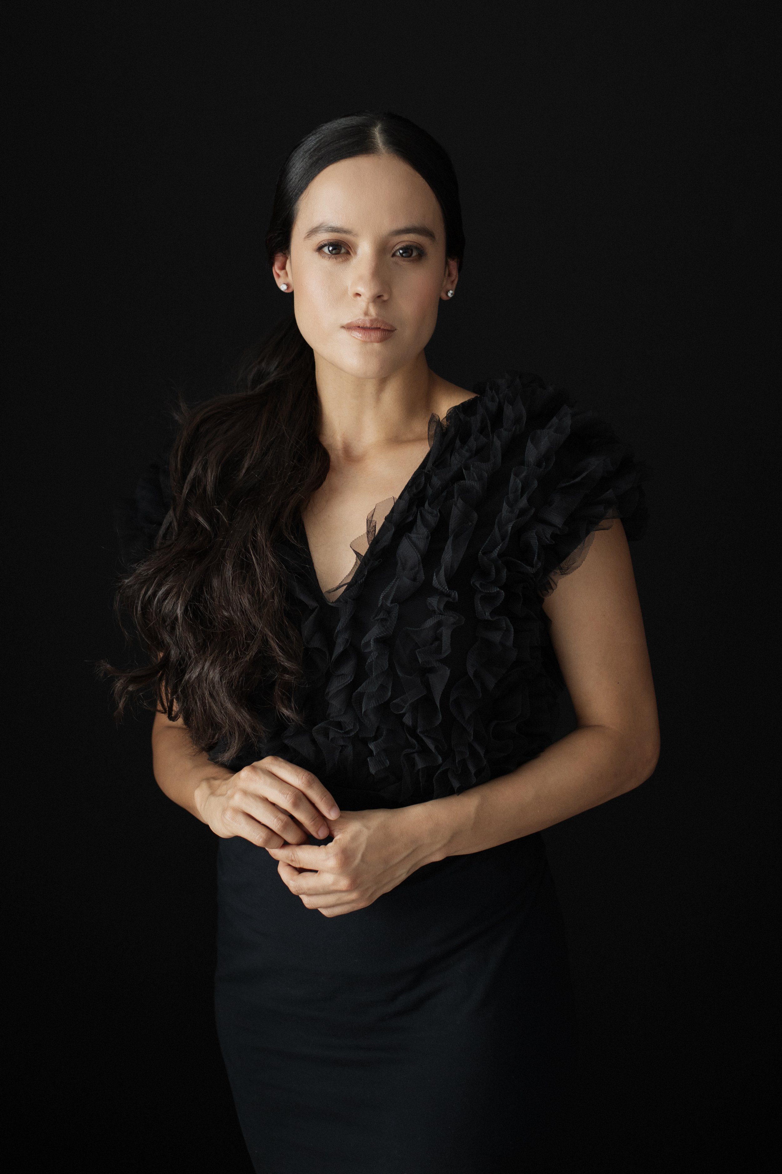 Captivating portrait of a woman in a black dress, striking a pose for a photography Miami Pilar Andujar photoshoot.