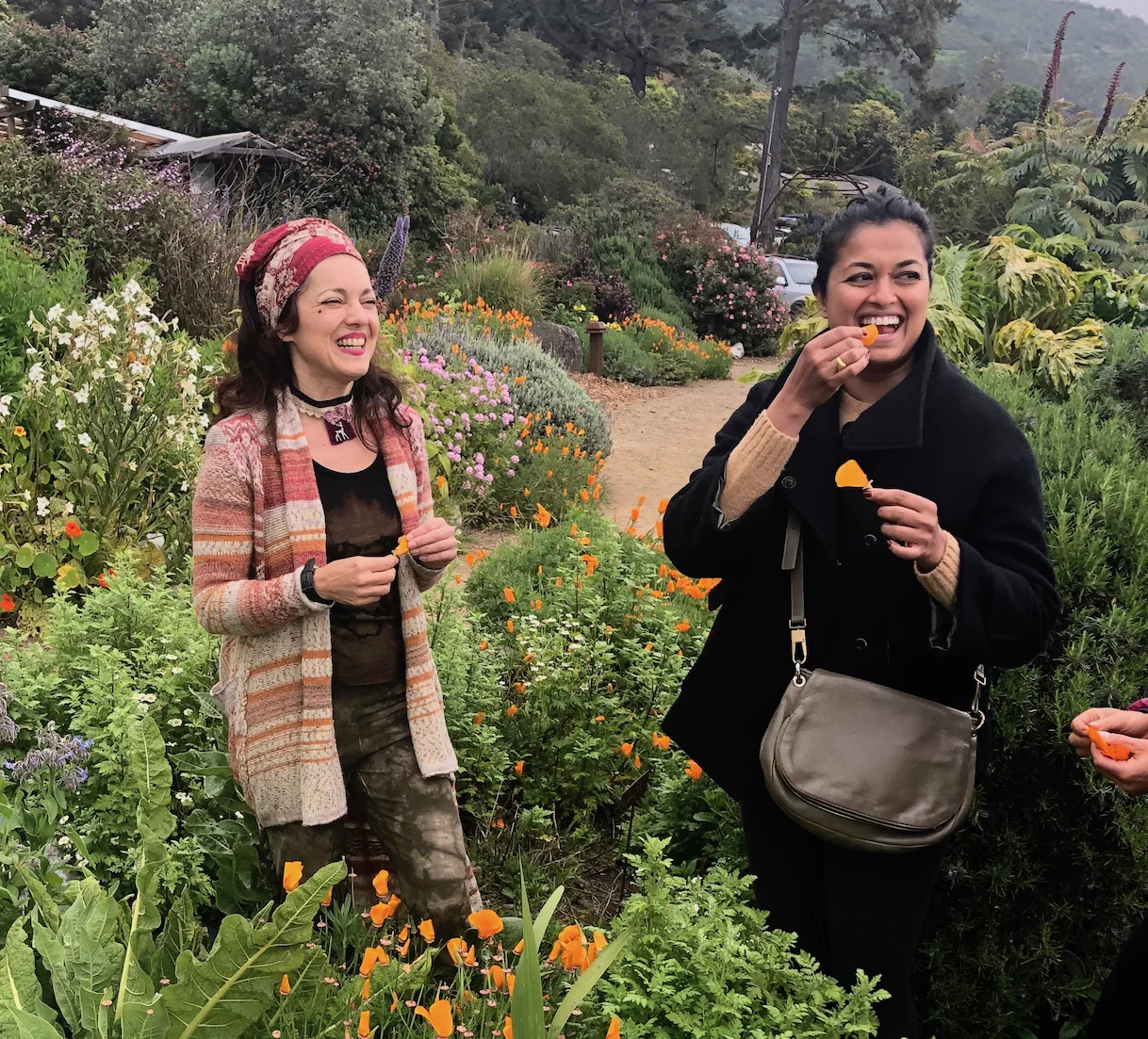 Shankari teaching class on edible flowers at Esalen Institute while student tastes a flower