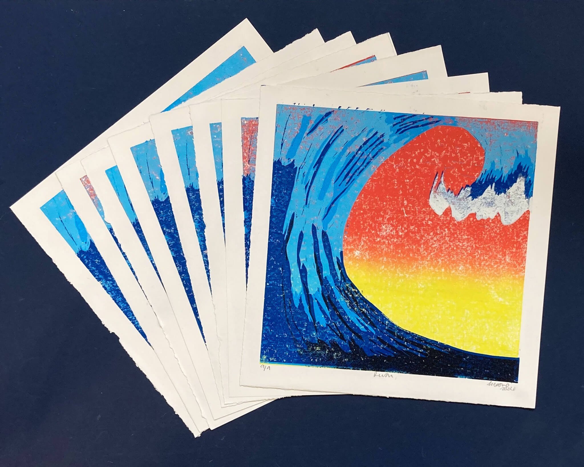 9 original prints fanned out on navy background: Rush Tidal Wave Print in 5 blues and blended tangerine orange and lemon yellow
