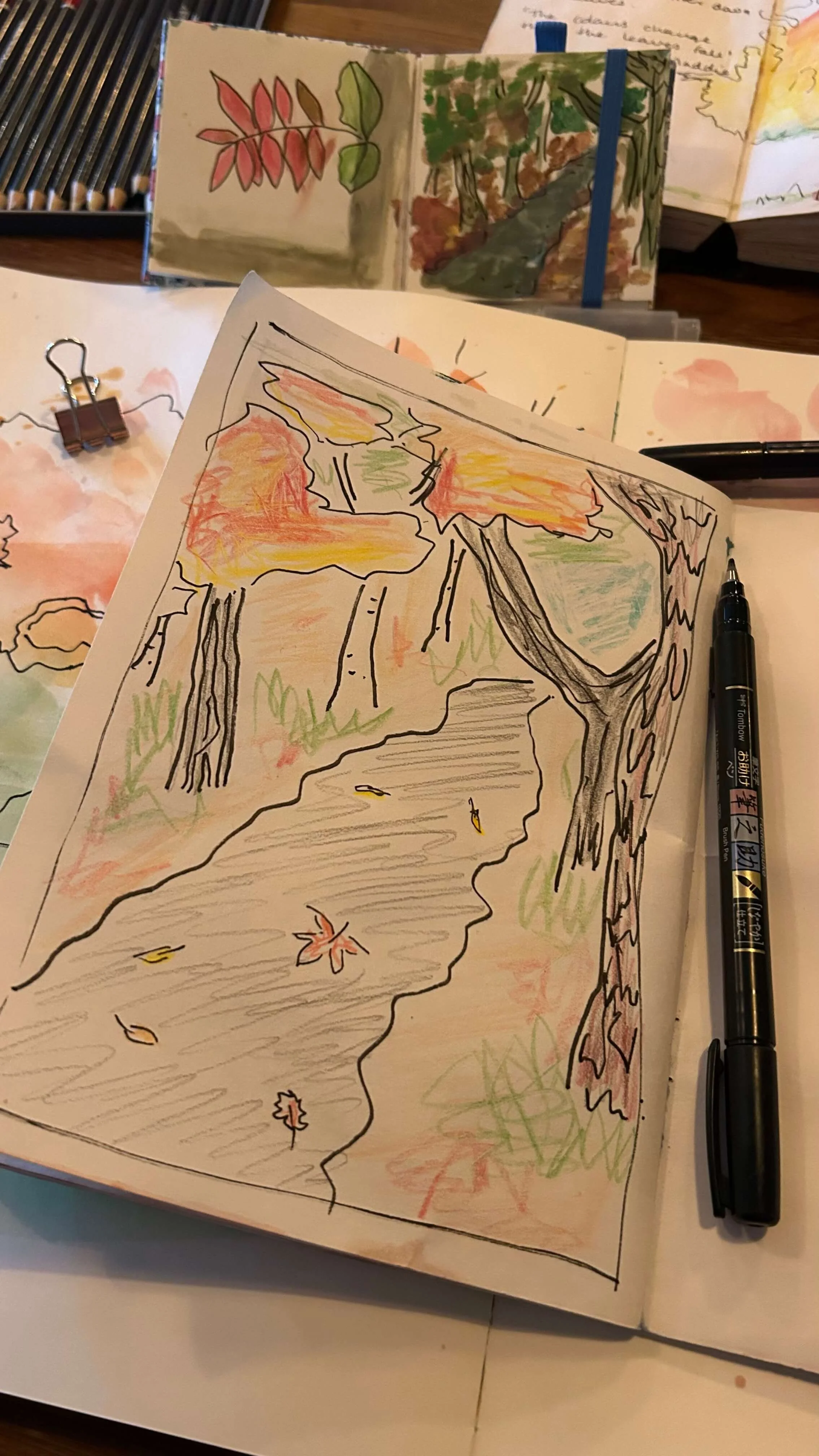 Sketchbook pile on a table with a hot chocolate