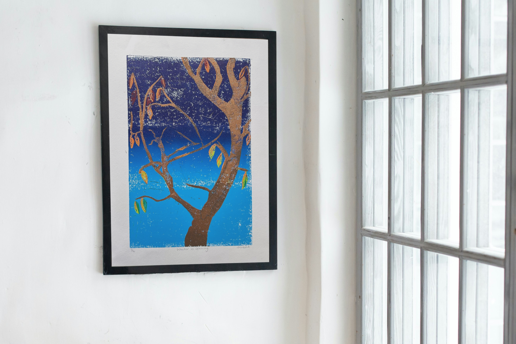 'Winter is Coming' Limited edition linocut - copper trunk against an ombre blue sky with leaves in green, yellow, orange and red