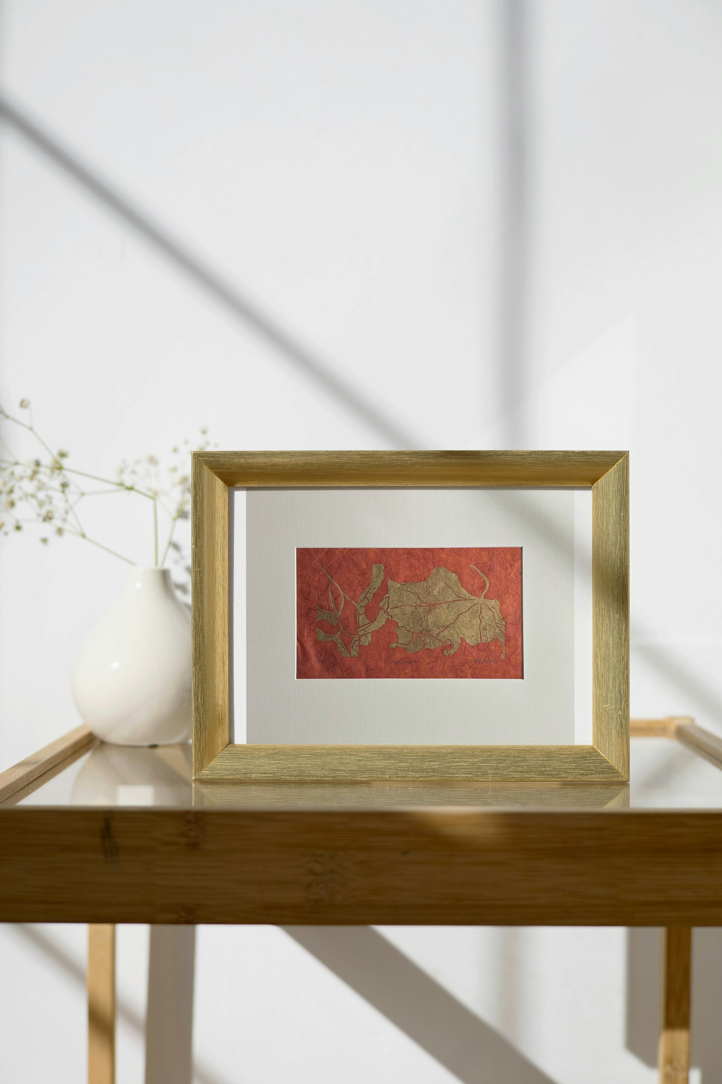 Sycamore Metallic Linocut on Orange on Metal Frame on Side Table.png