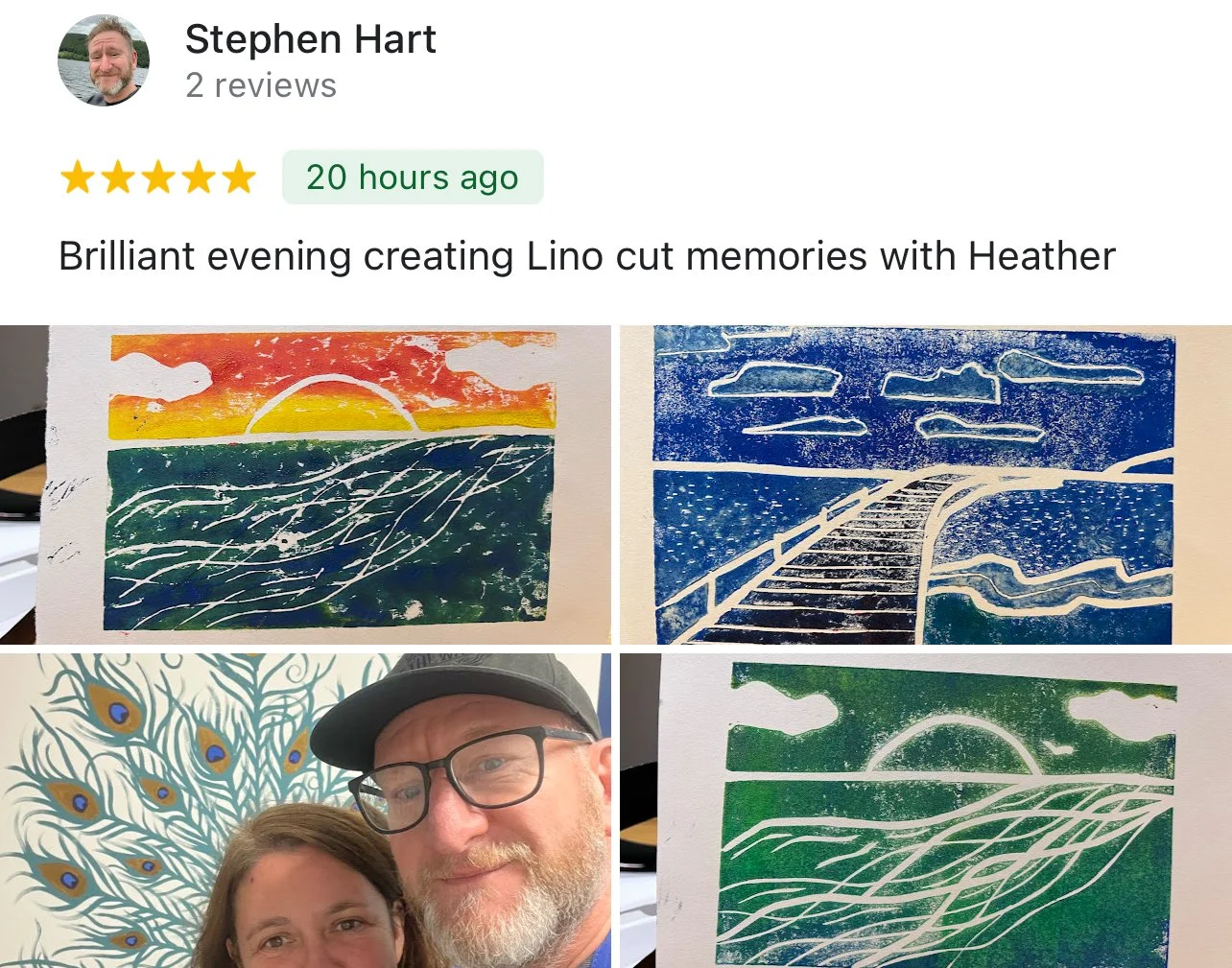 Photo of a couple in front of a peacock feather art piece, with four Lino cut art prints depicting a sunset or sunrise over water and a bridge.