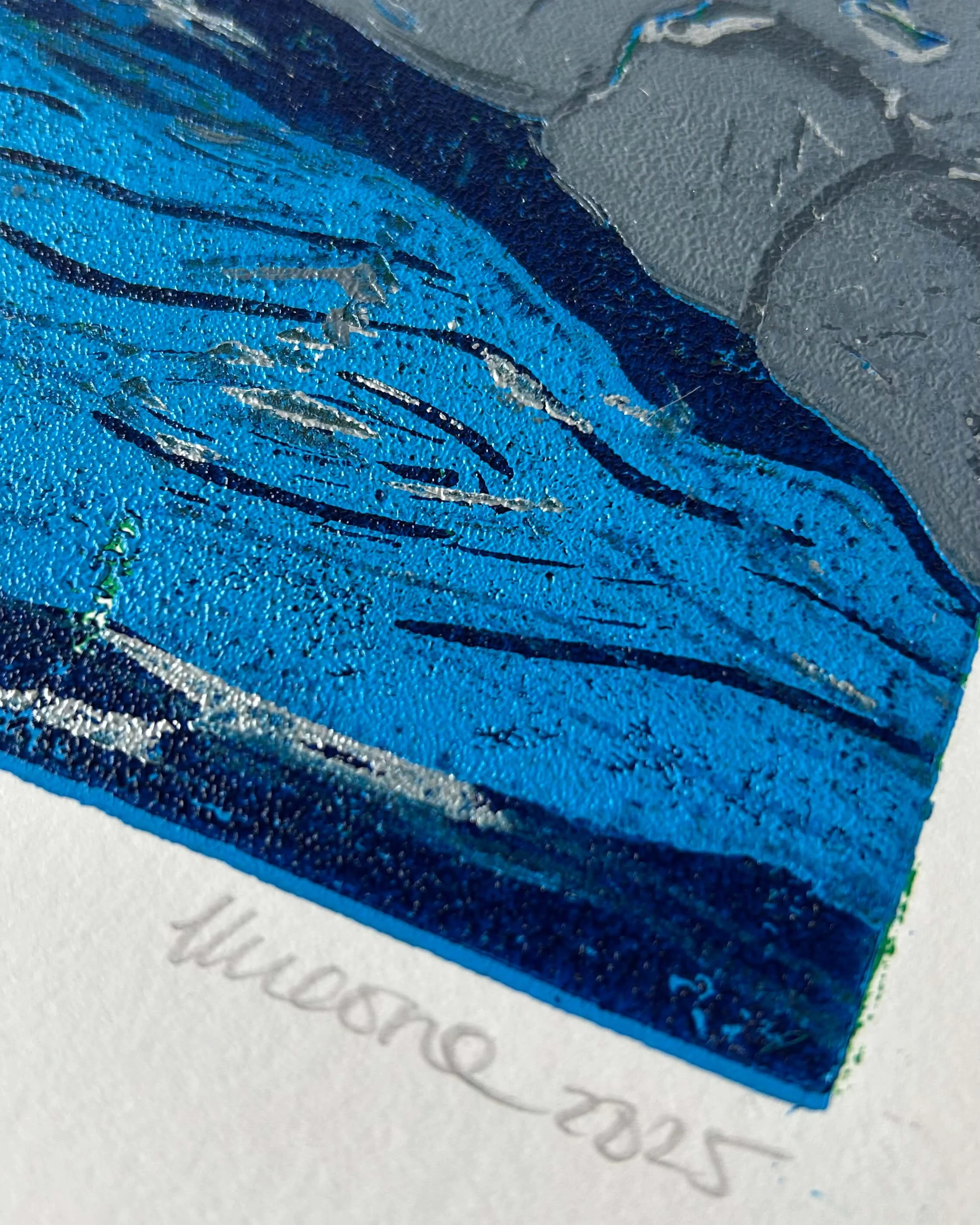 Close up of The Skipping Bridge - a lino reduction print of a silver grey stone bridge over a rippling blue river