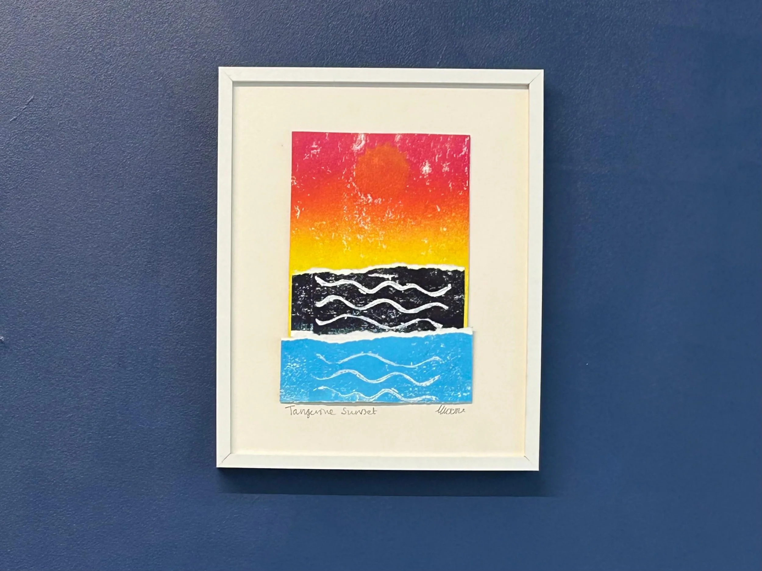 Pink and yellow blend mixed media collage and print in white frame on navy wall