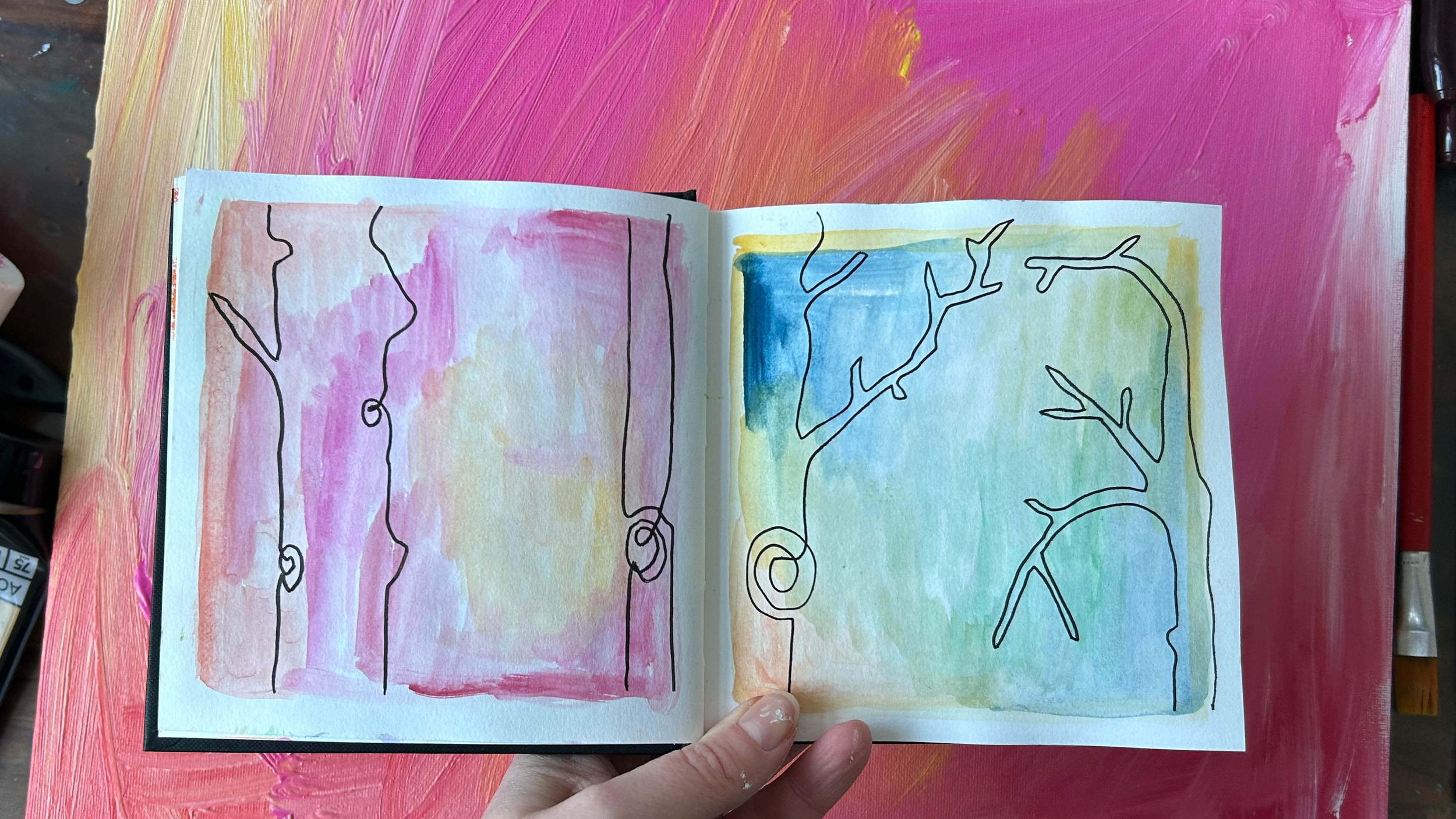 Sketchbook spread against pink canvas