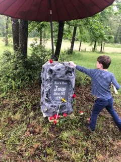 Kids put flowers on Jesus' grave.