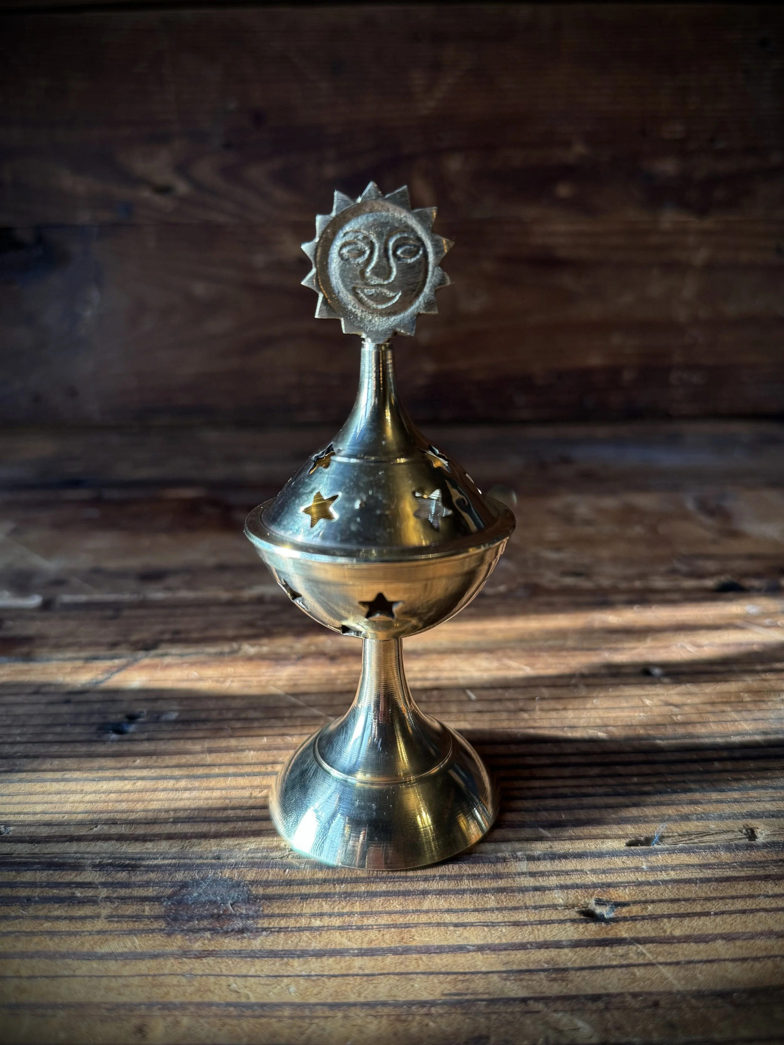brass celestial cone incense burner with a removable top, cutout stars, and sun, moon, or star top decoration