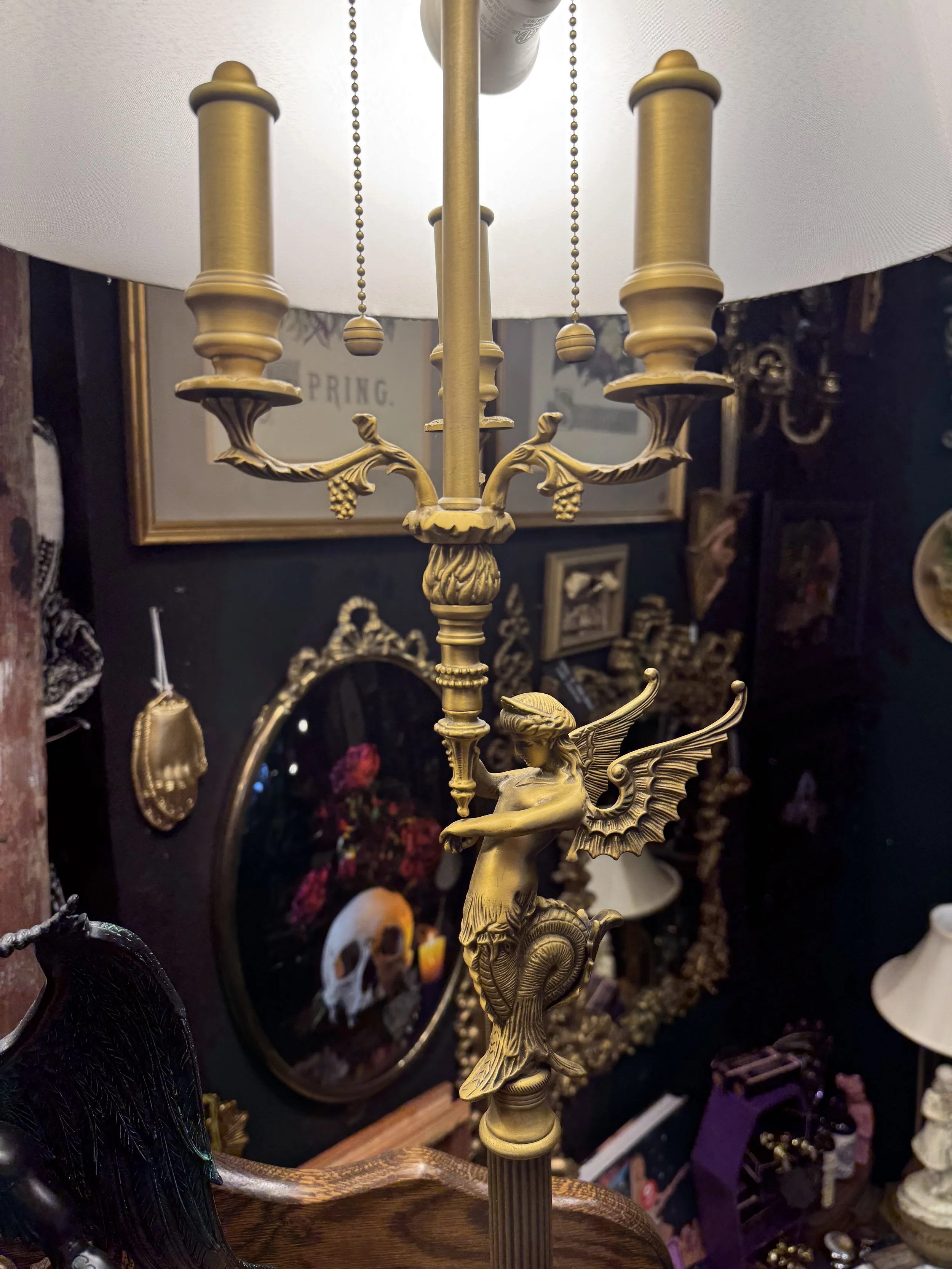 Antique gilded siren lamps with a white shade and a wooden base. Dual lightbulbs with pull chain.