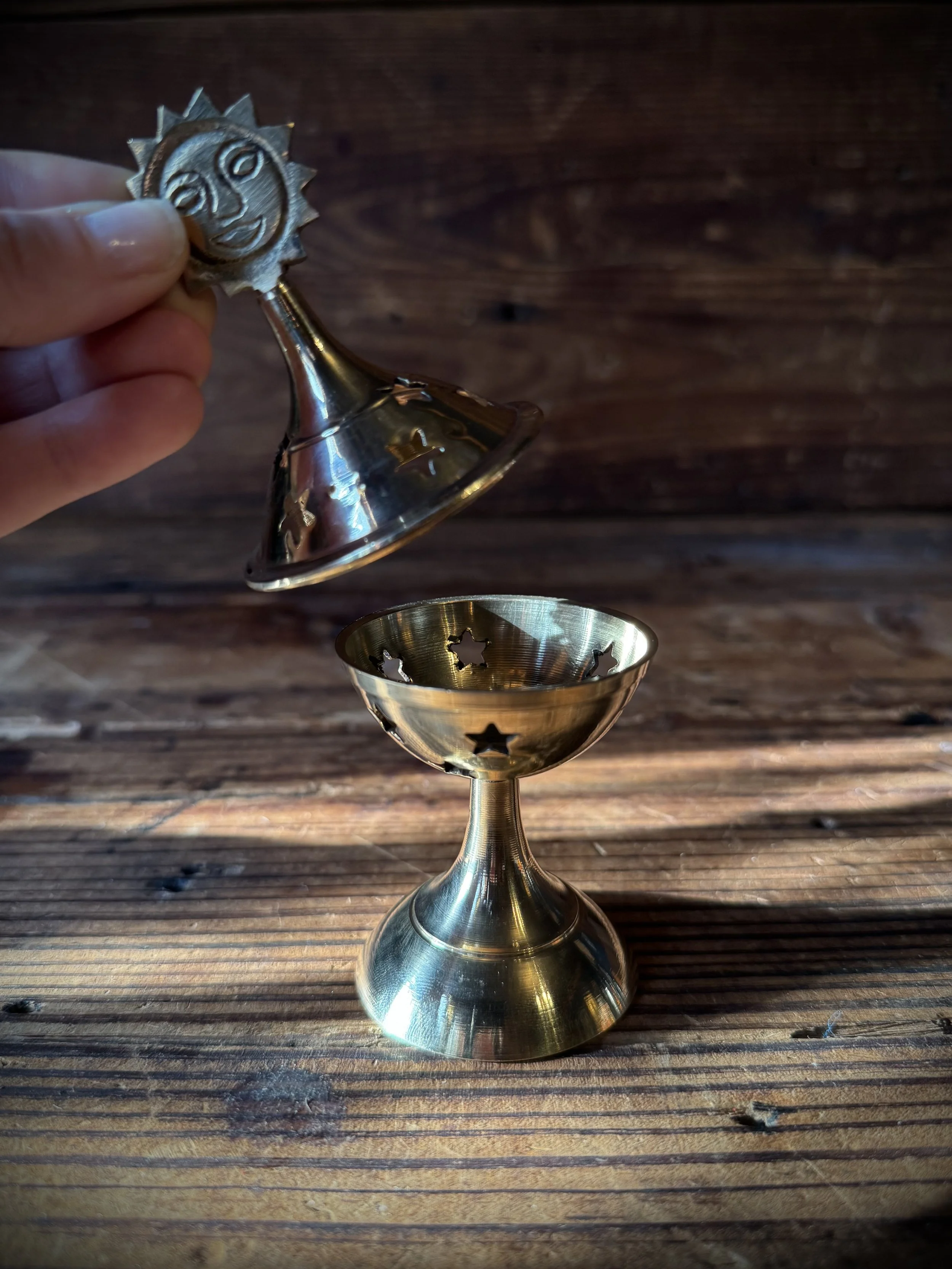 brass celestial cone incense burner with a removable top, cutout stars, and sun, moon, or star top decoration