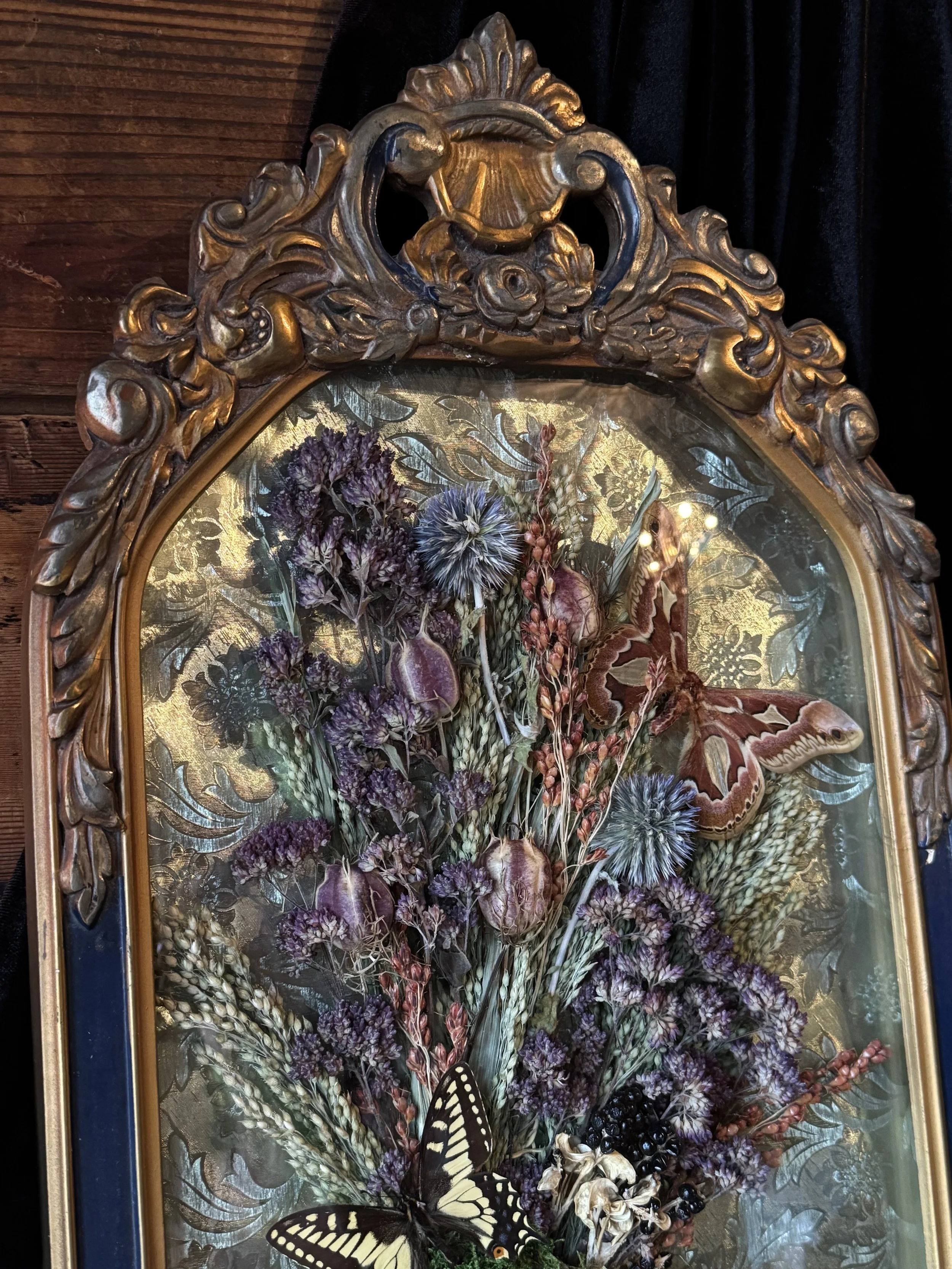 victorian style floral and butterfly wreath set in a vintage bubble glass frame
