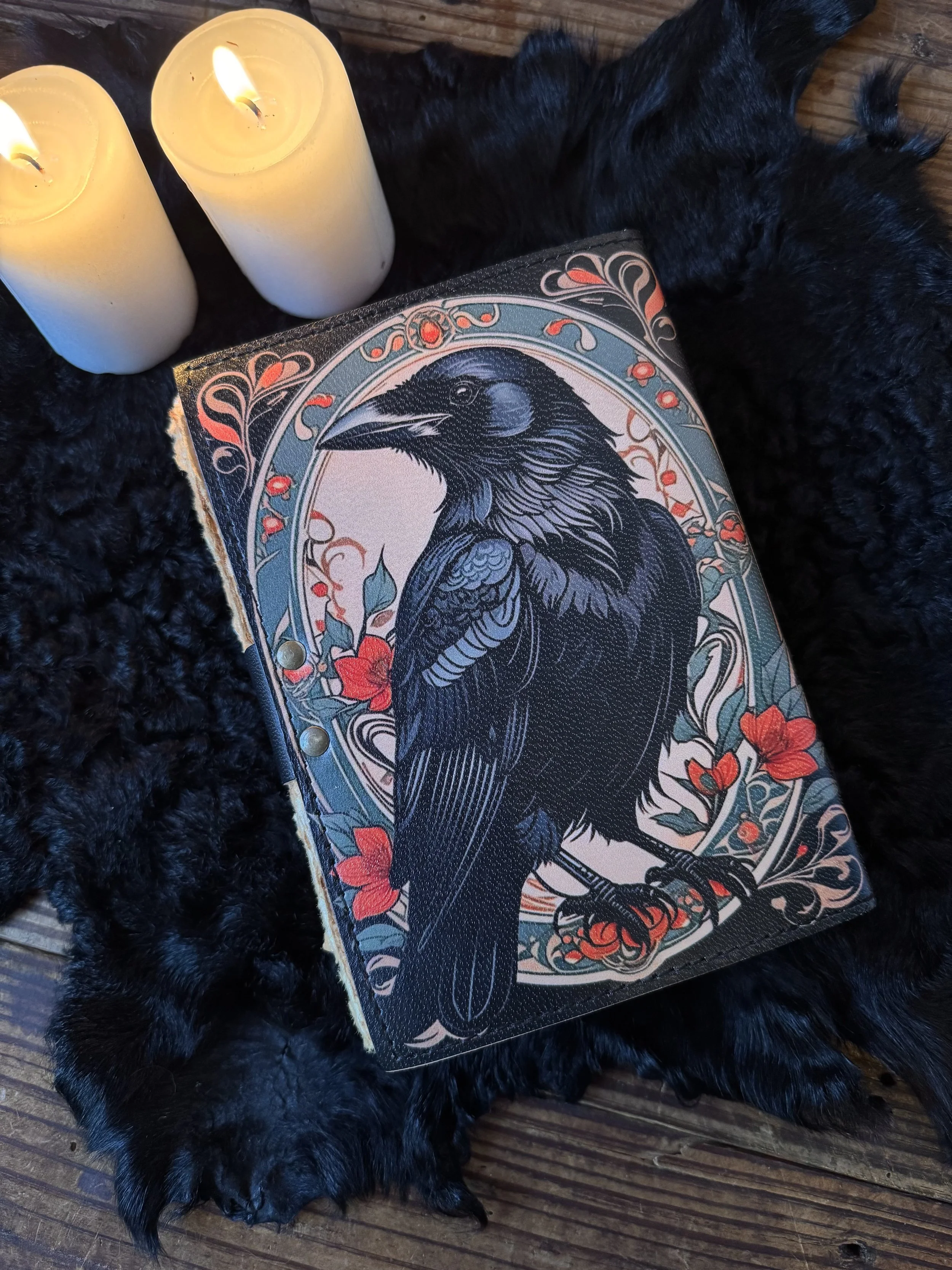 faux leather parchment paper journal with a large bol black raven on the front with green and red foliage
