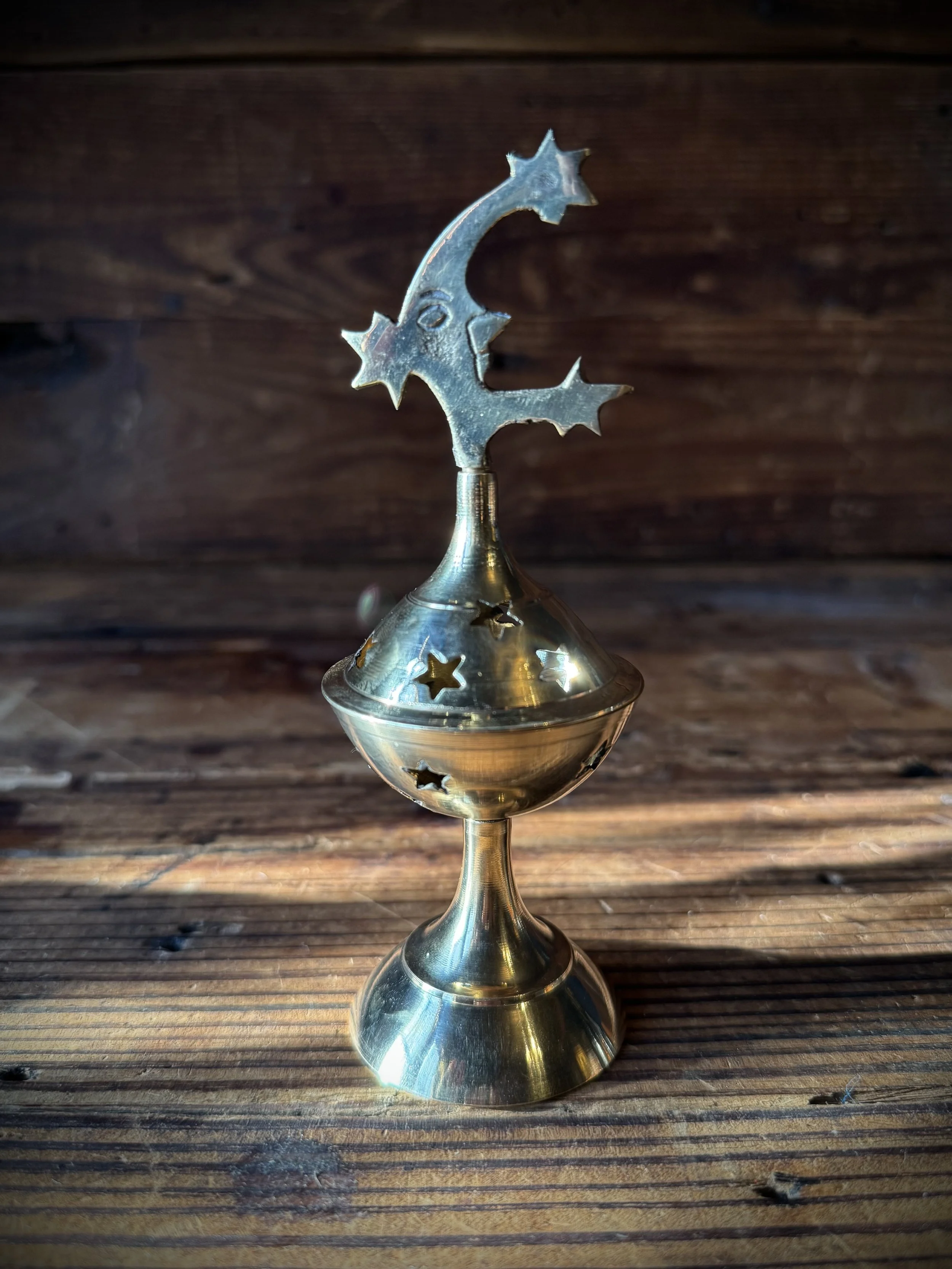 brass celestial cone incense burner with a removable top, cutout stars, and sun, moon, or star top decoration