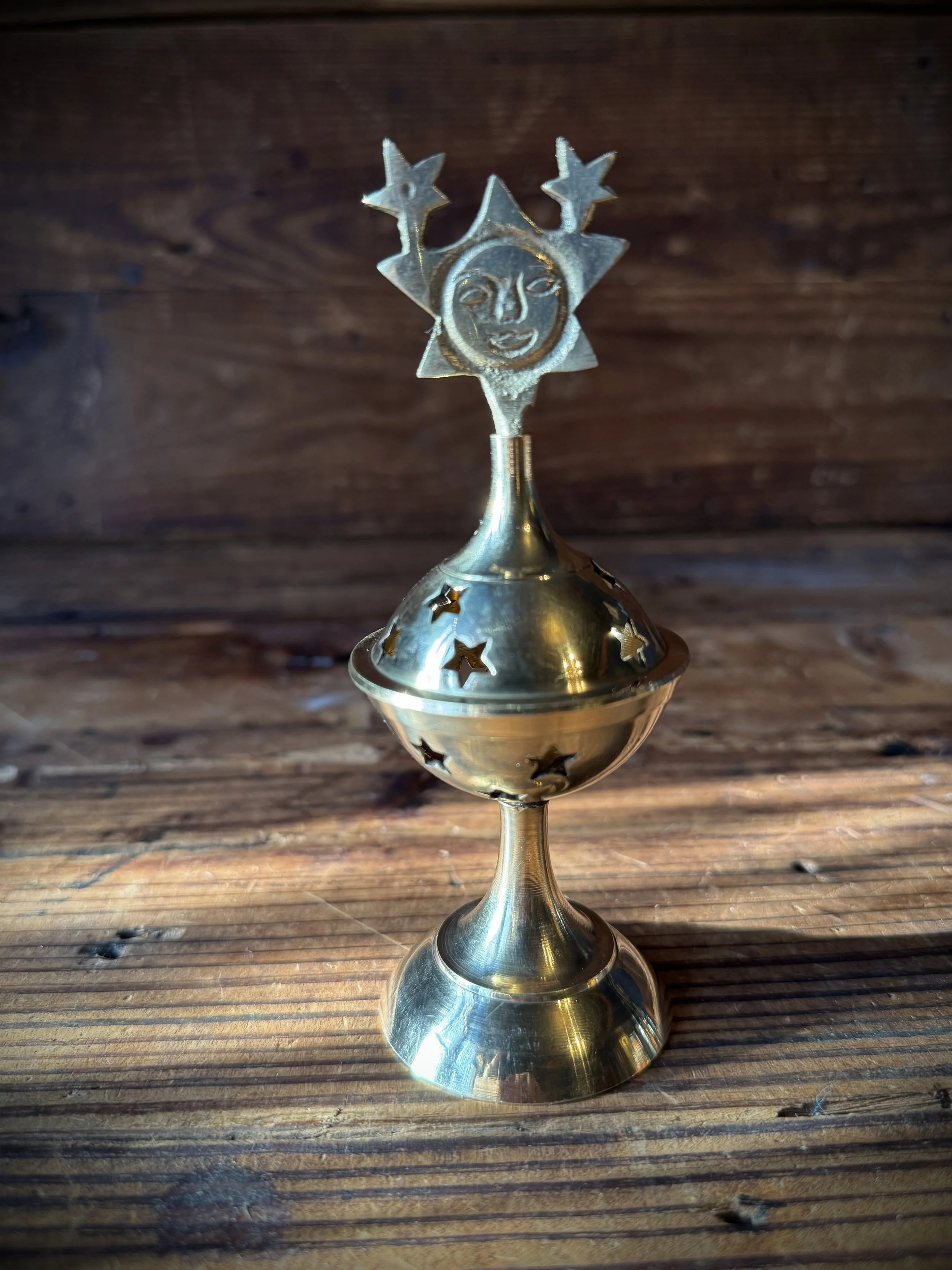 brass celestial cone incense burner with a removable top, cutout stars, and sun, moon, or star top decoration