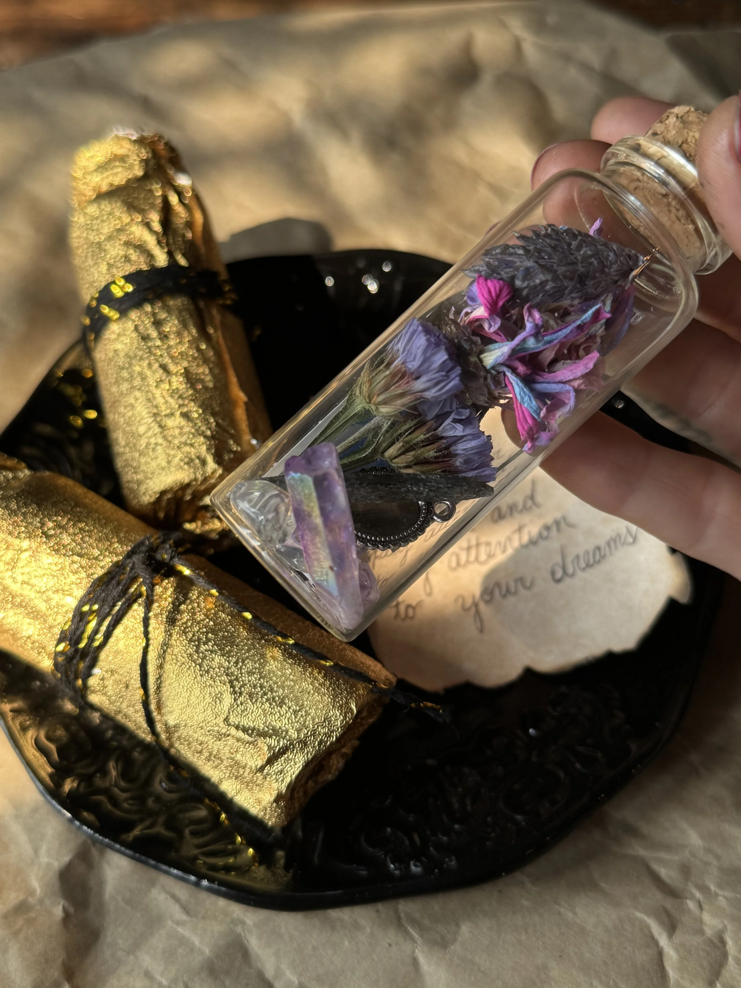 Tarot inspired mystery foil bottles wrapped in golden foil and containing dried flora nd crystals.