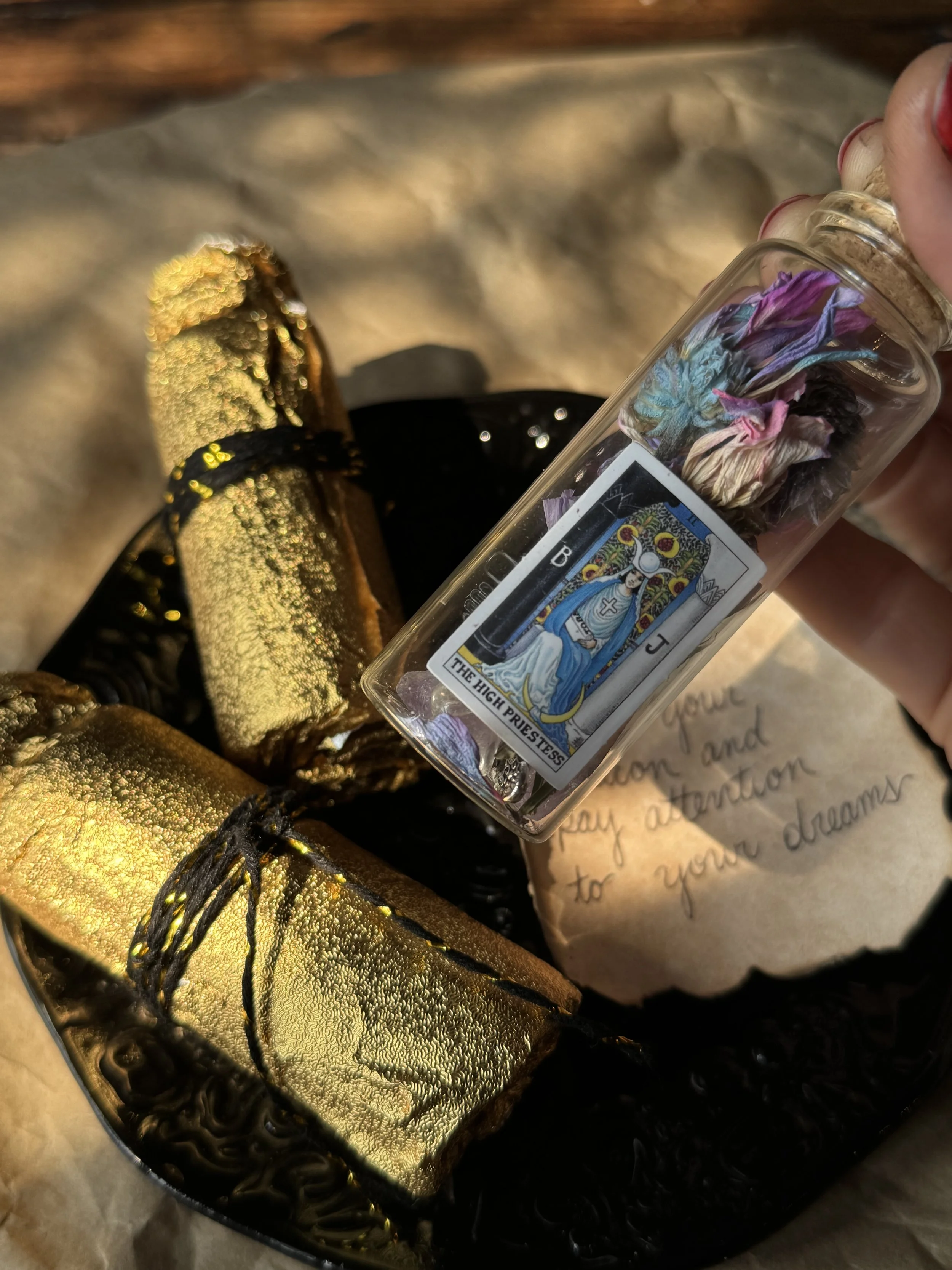 Tarot inspired mystery foil bottles wrapped in golden foil and containing dried flora nd crystals.