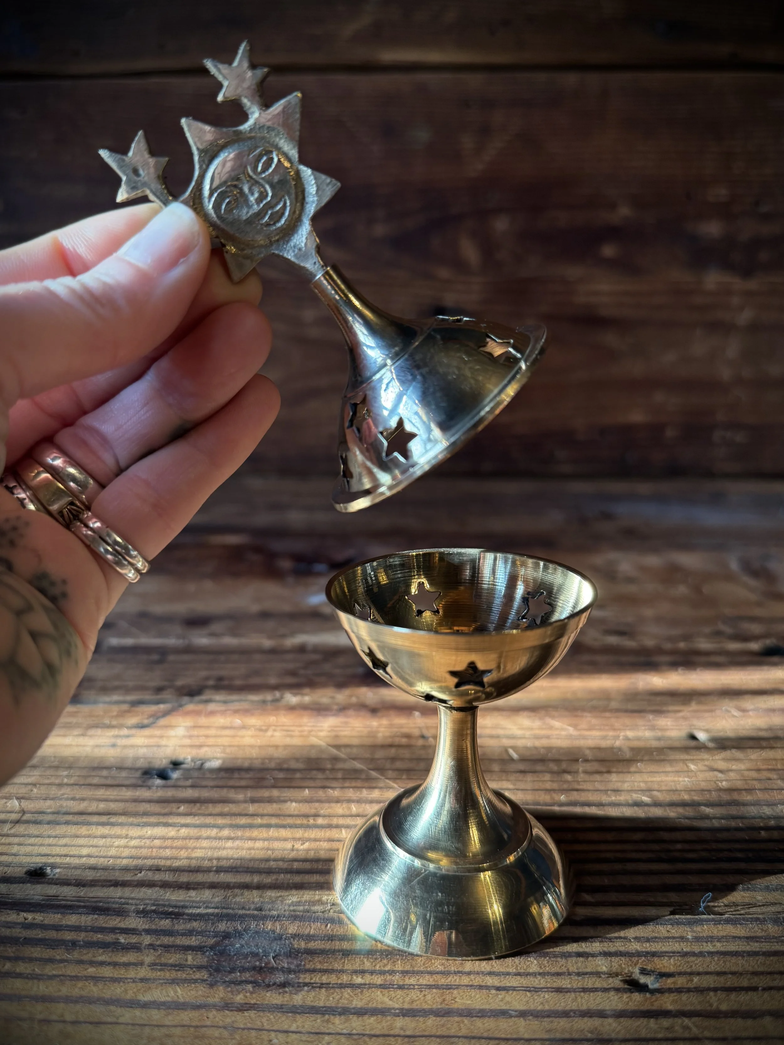 brass celestial cone incense burner with a removable top, cutout stars, and sun, moon, or star top decoration