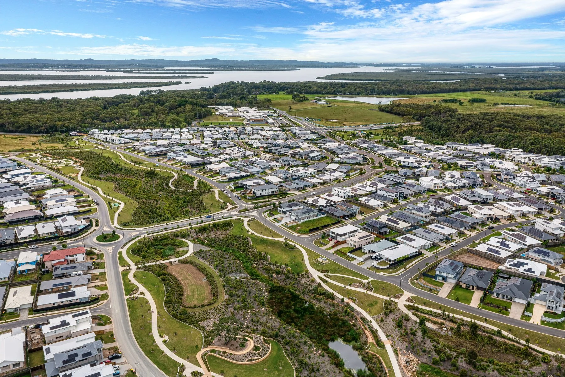  High altitude aerial of coastal suburb showing streets, parkland and ocean in background — real estate drone photography Gold Coast 