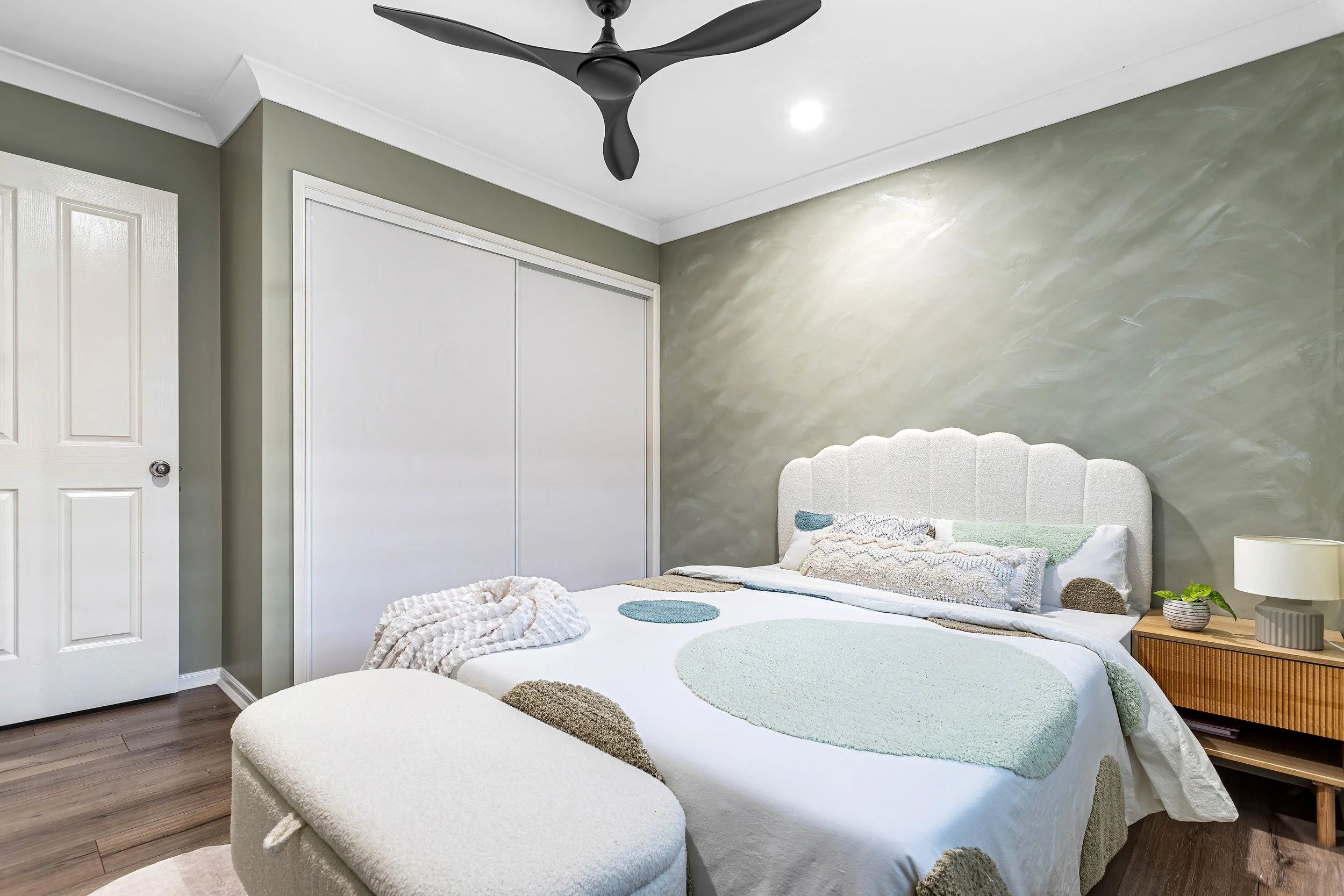  Bedroom at 13 Zac Avenue, Coombabah with black ceiling fan, olive feature wall and boucle headboard 