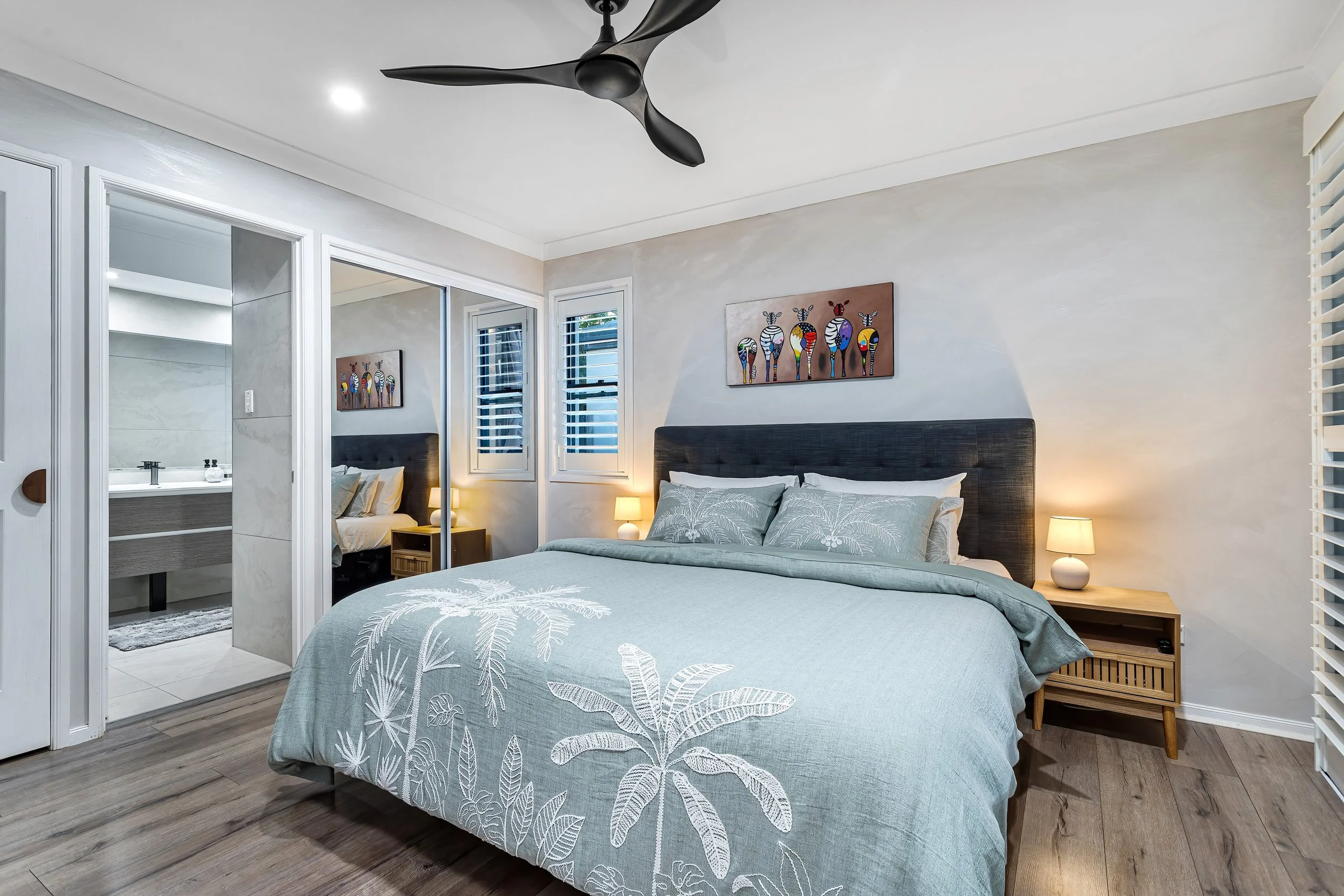  Bedroom at 13 Zac Avenue, Coombabah with black ceiling fan, mirrored wardrobe and soft sage-toned bedding 